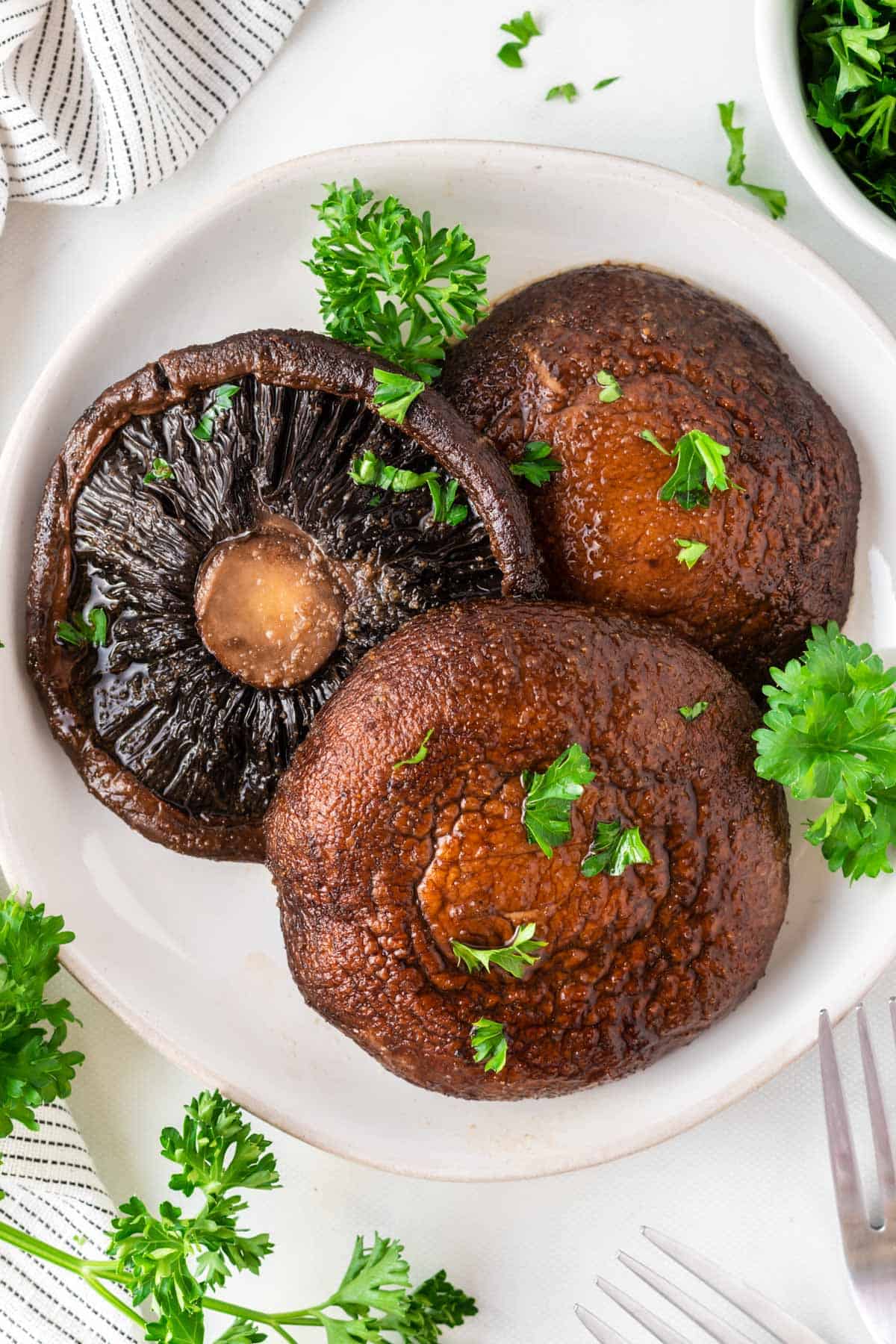 portobello mushrooms topped with parsley on a plate