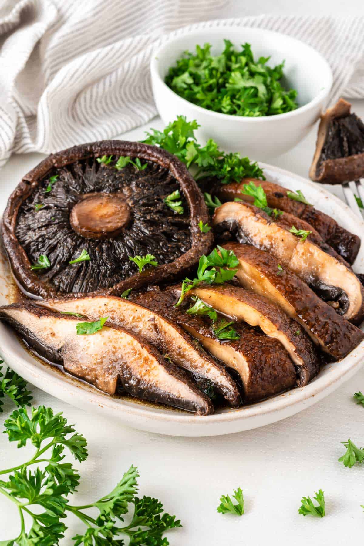 portobello mushrooms cut into slices topped with parsley on a plate