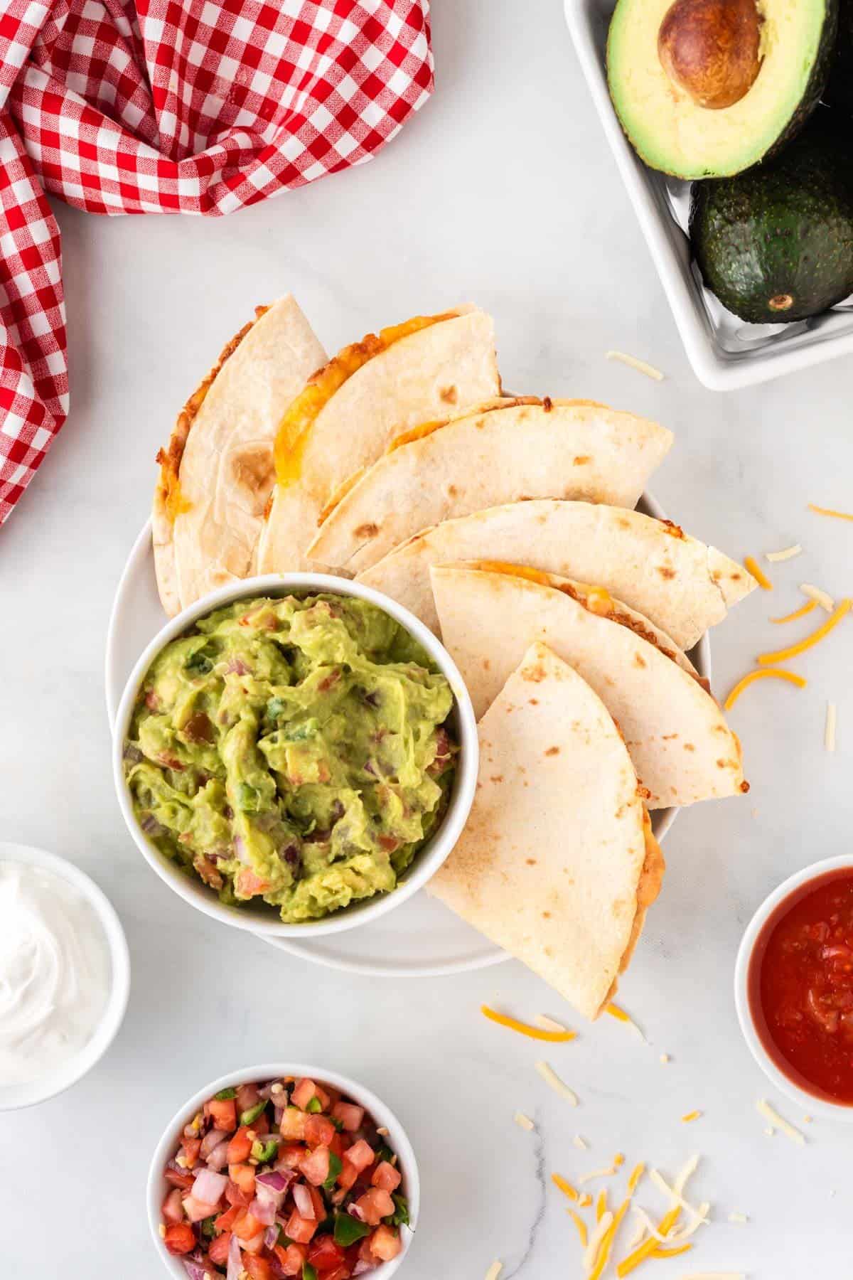air fryer quesadillas next to guacamole on a plate