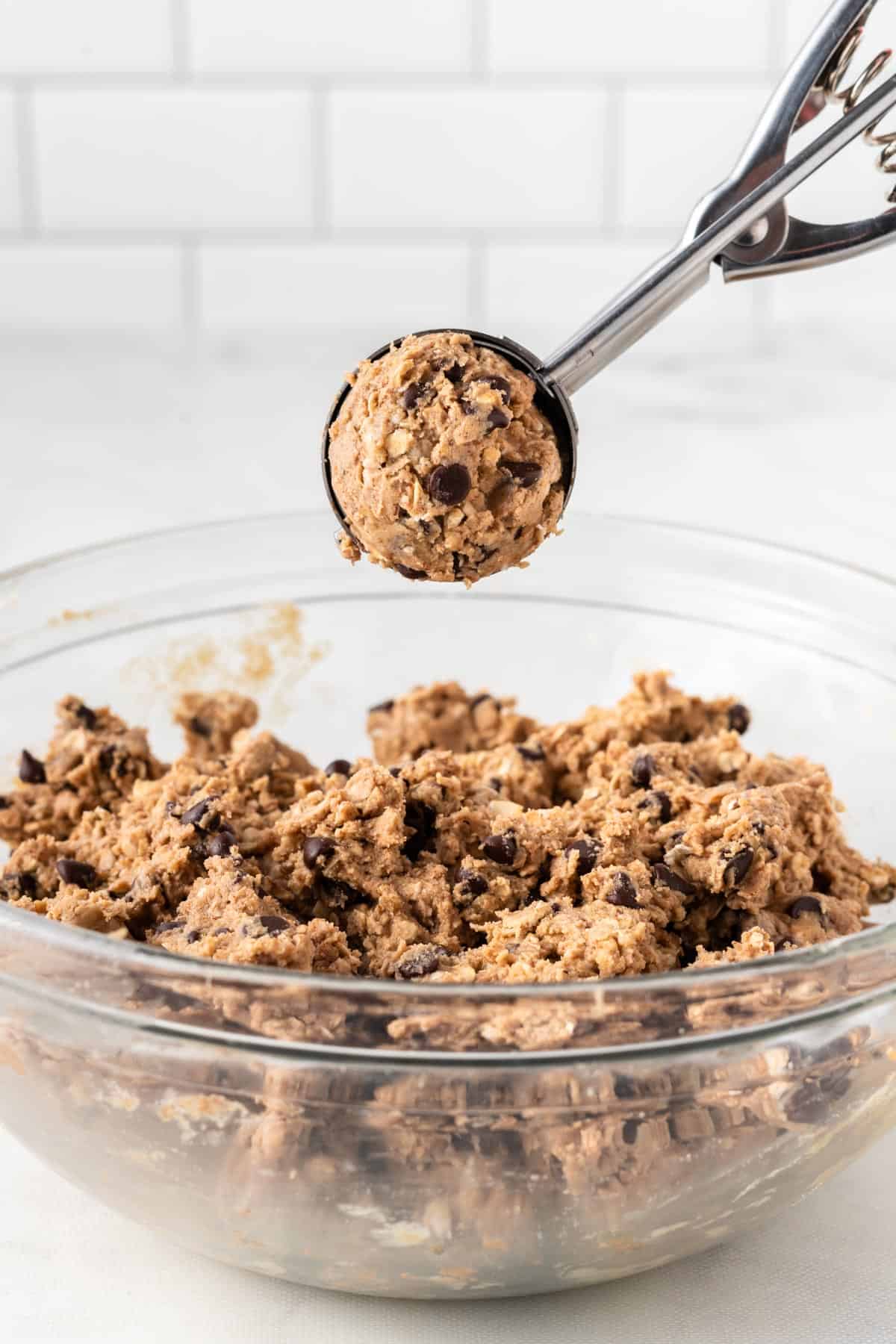 mini cookie scoop holding a scoop of energy ball batter