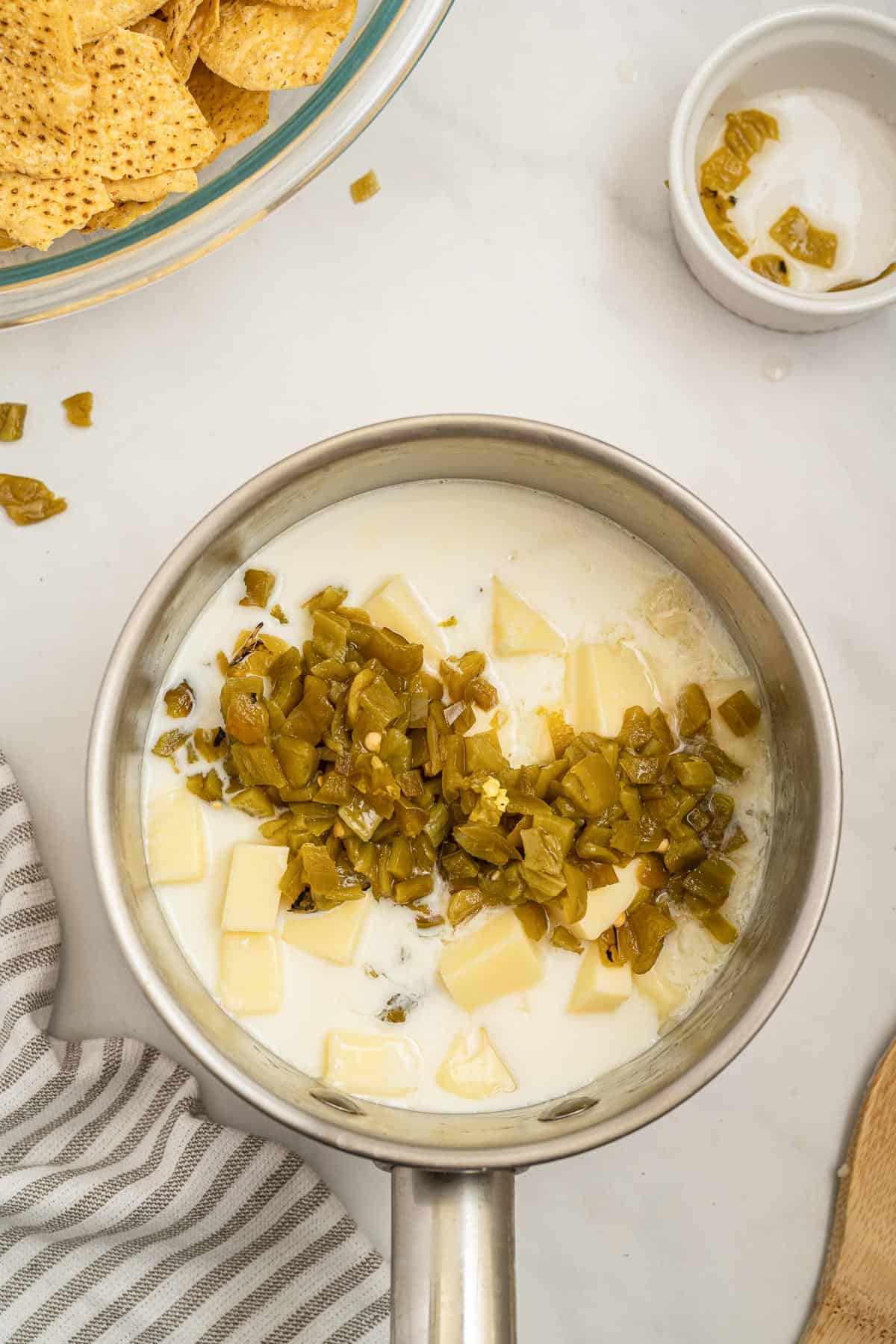 adding milk and jalapeno peppers to the american cheese