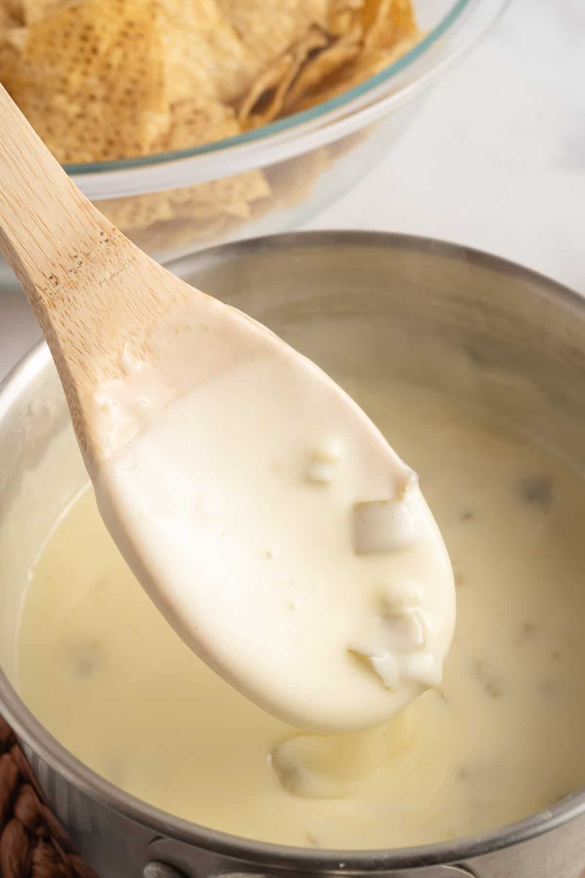 wooden spoon stirring queso blanco