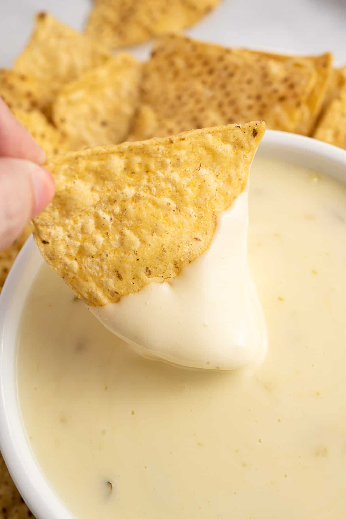 dipping a chip into queso blanco