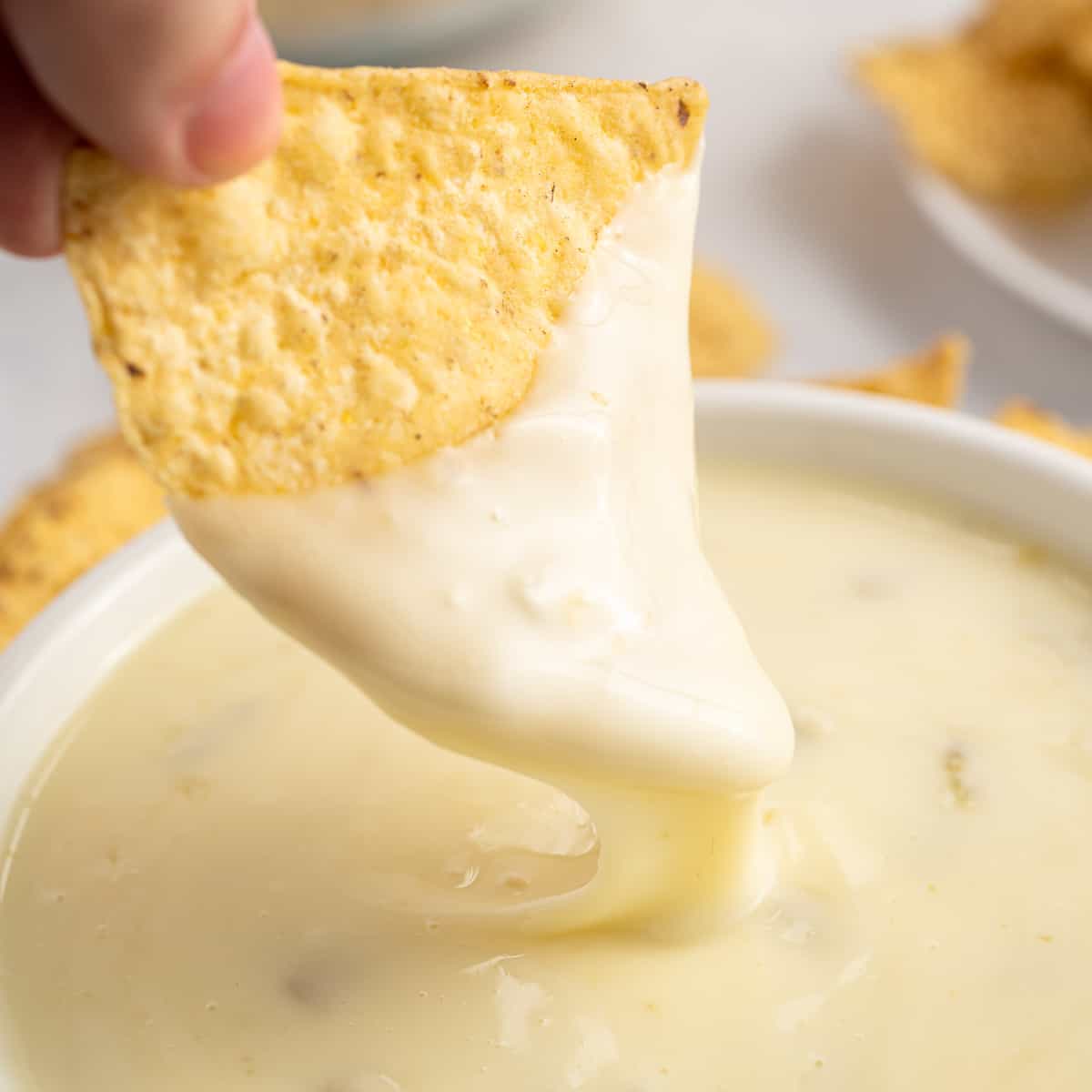 dipping a chip into queso blanco