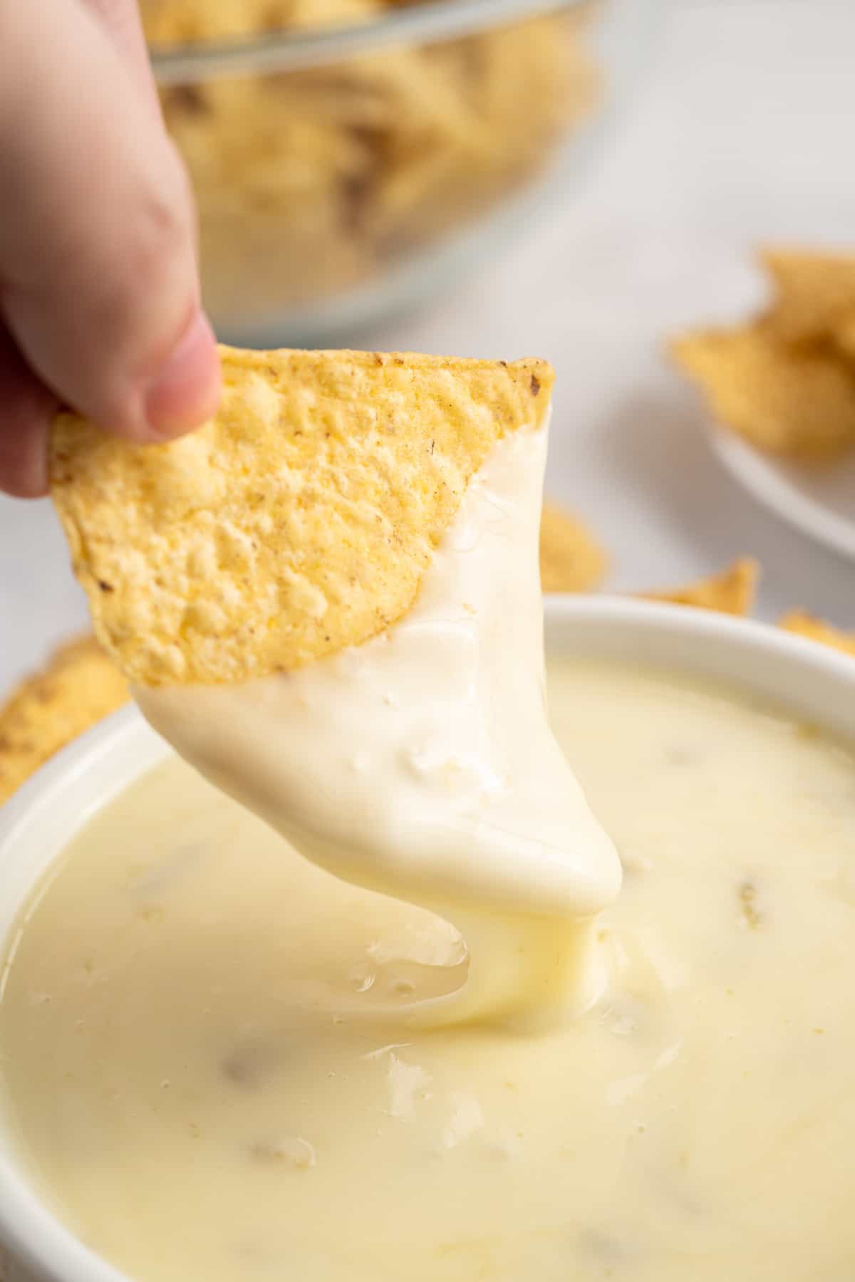 dipping a chip into queso blanco