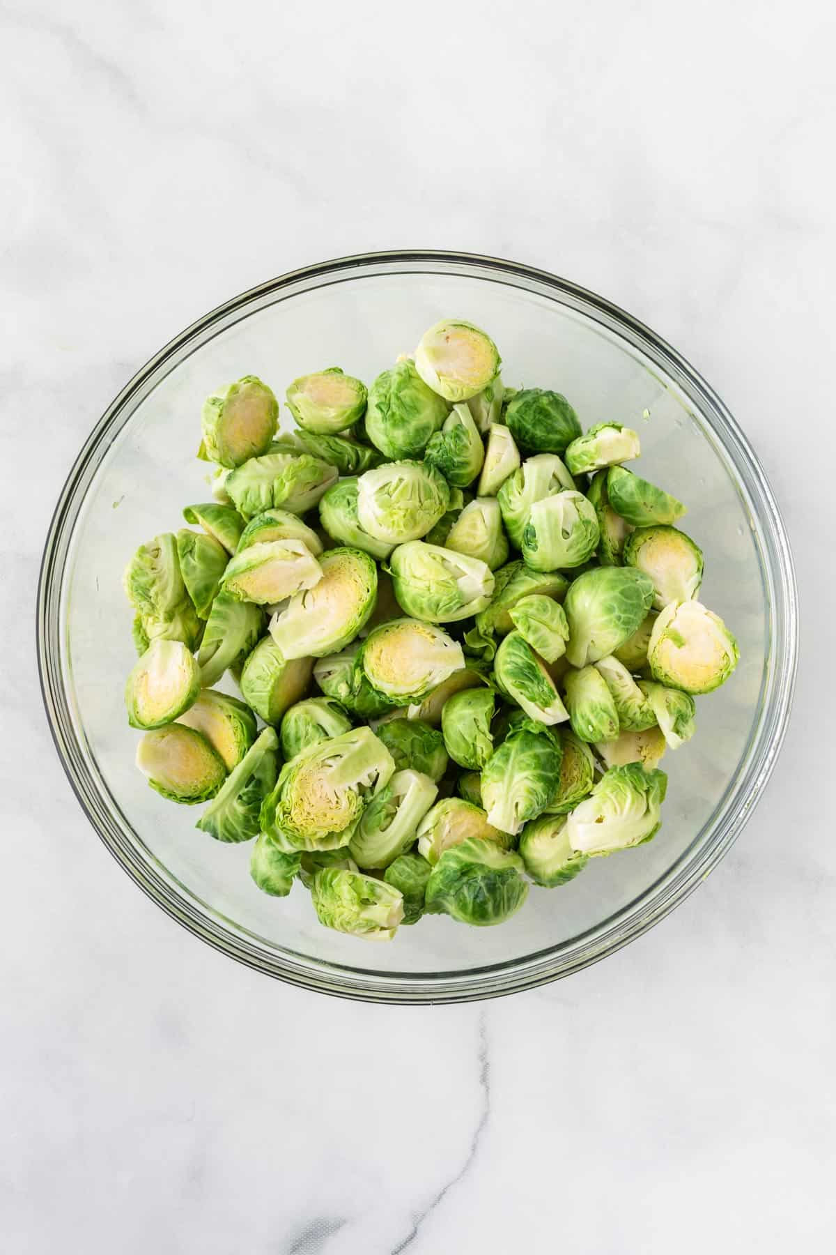 halved brussels sprouts in a glass bowl