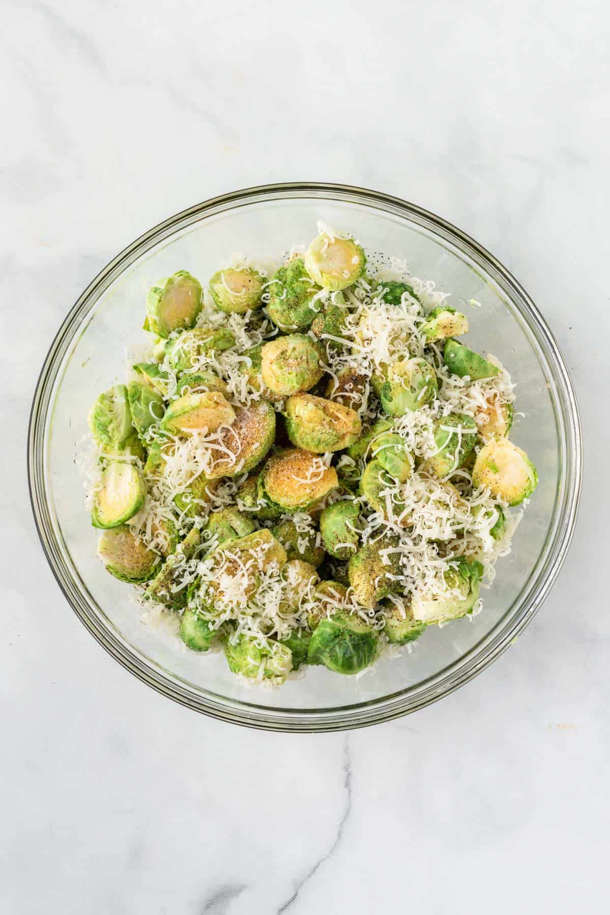 adding the spices and oil to the brussels sprouts