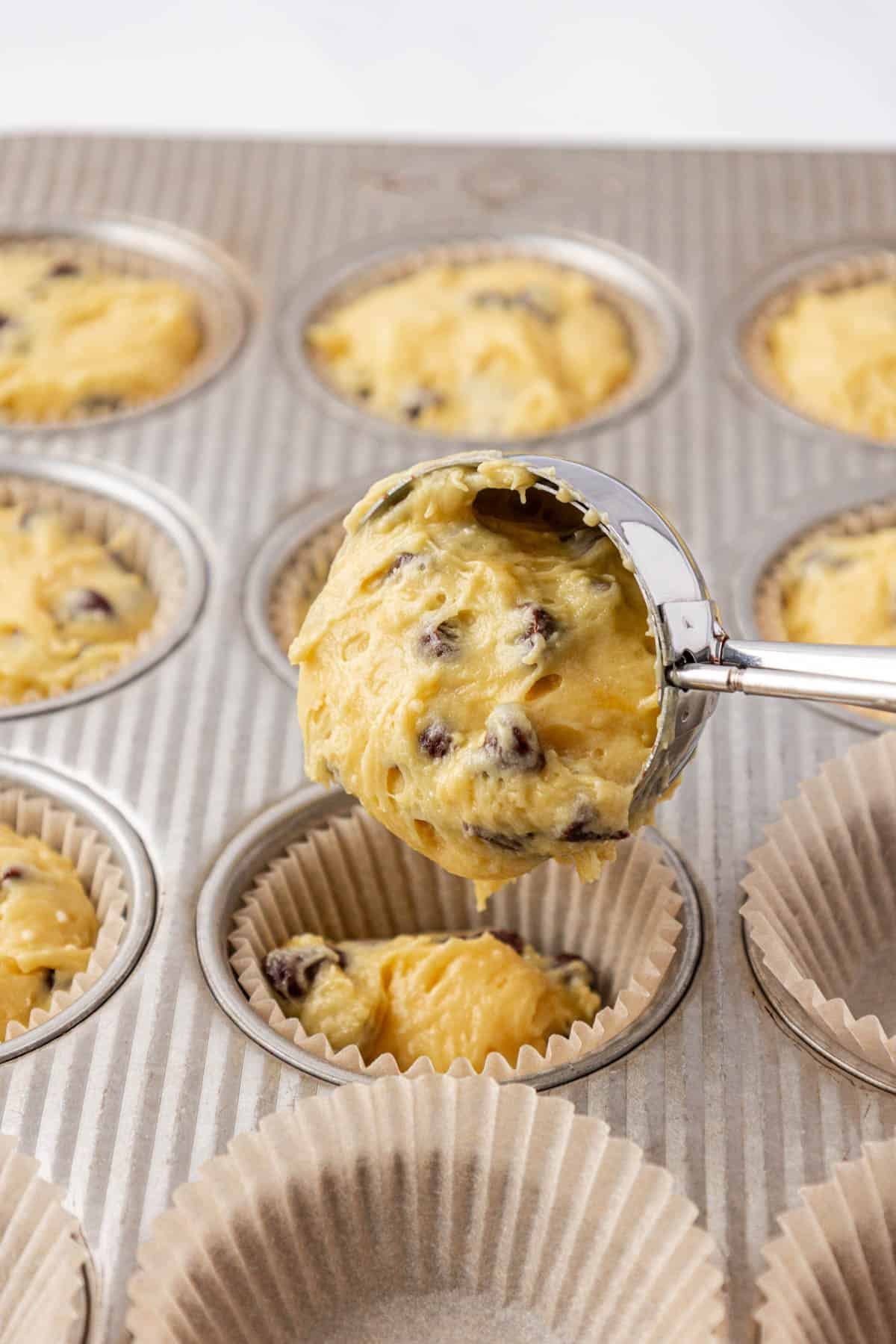 scooping batter into muffin liners