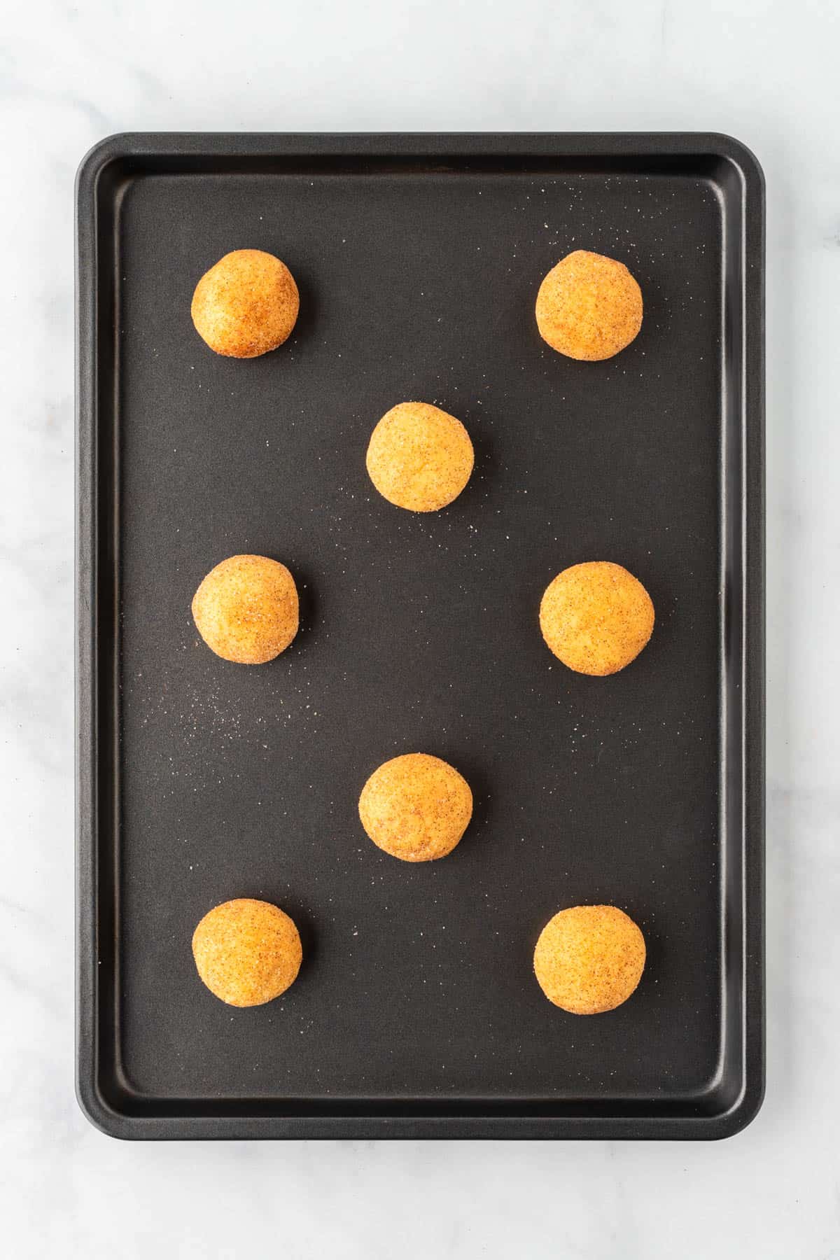 cookie dough in balls on a baking sheet