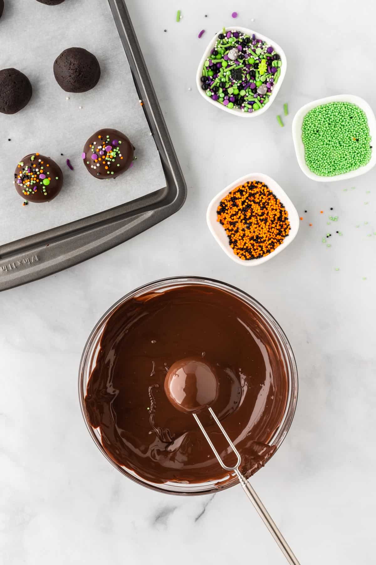 dipping an oreo ball into melted chocolate