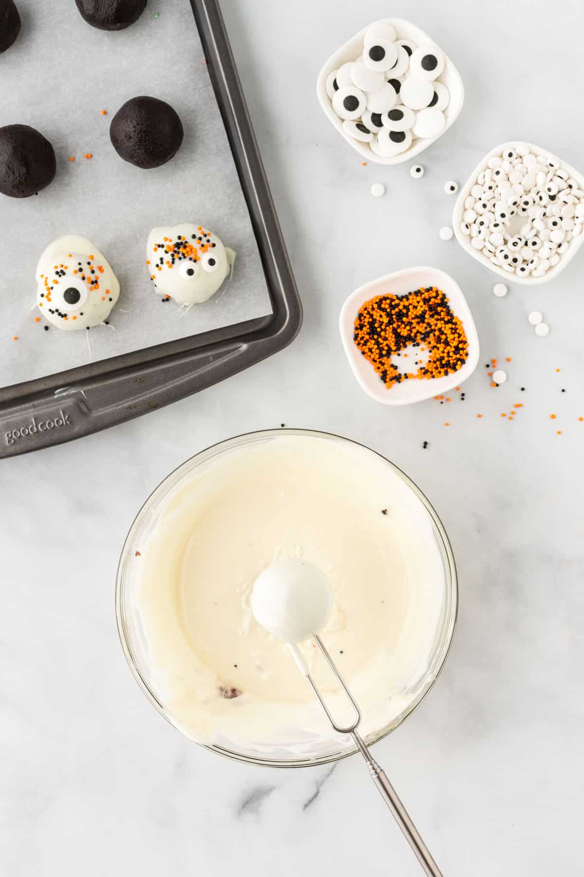 dipping an oreo ball into melted white chocolate