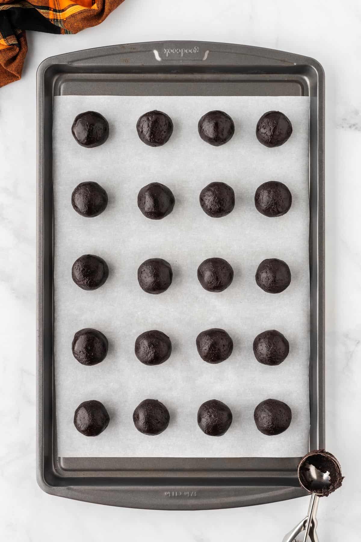 oreo balls lined up on a baking sheet
