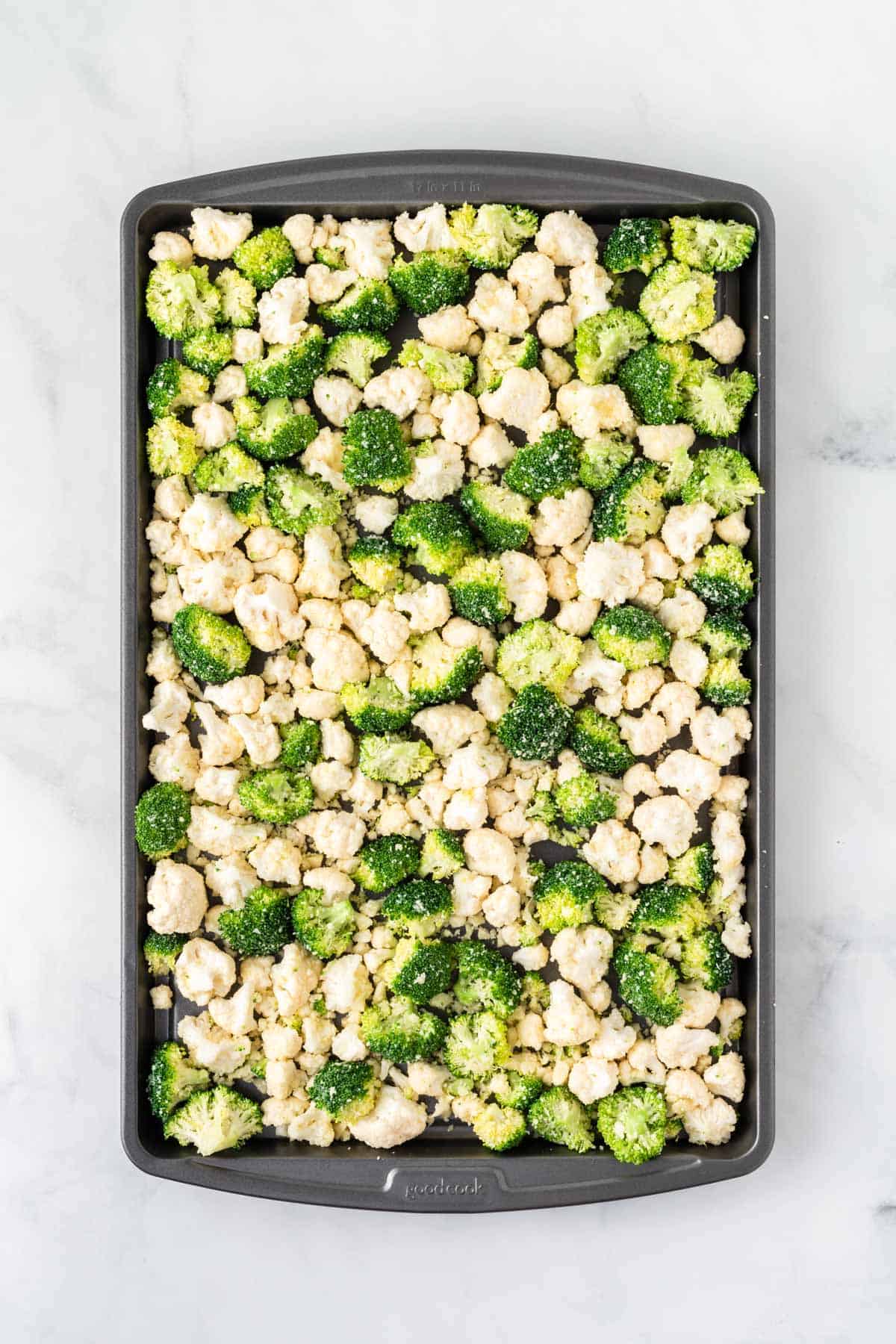 placing the broccoli and cauliflower on a baking sheet