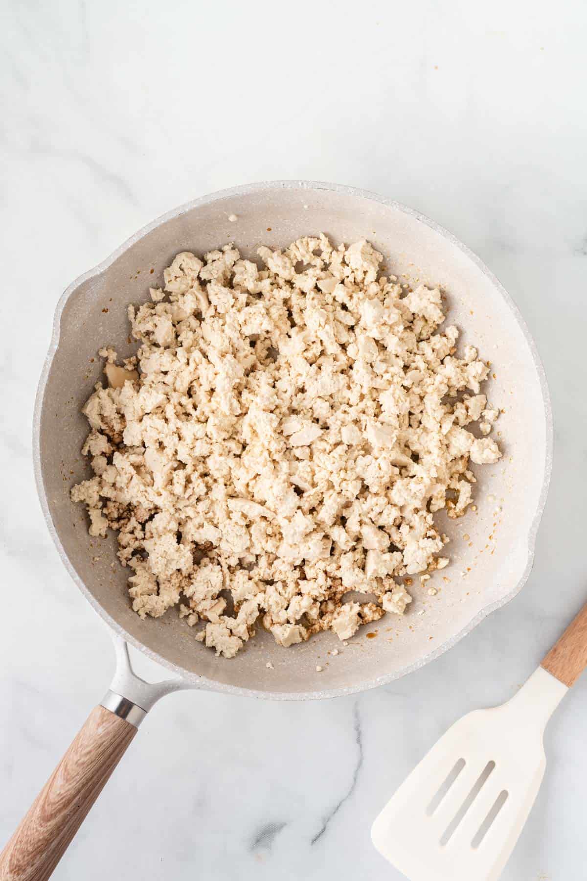 adding the crumbled tofu to the skillet