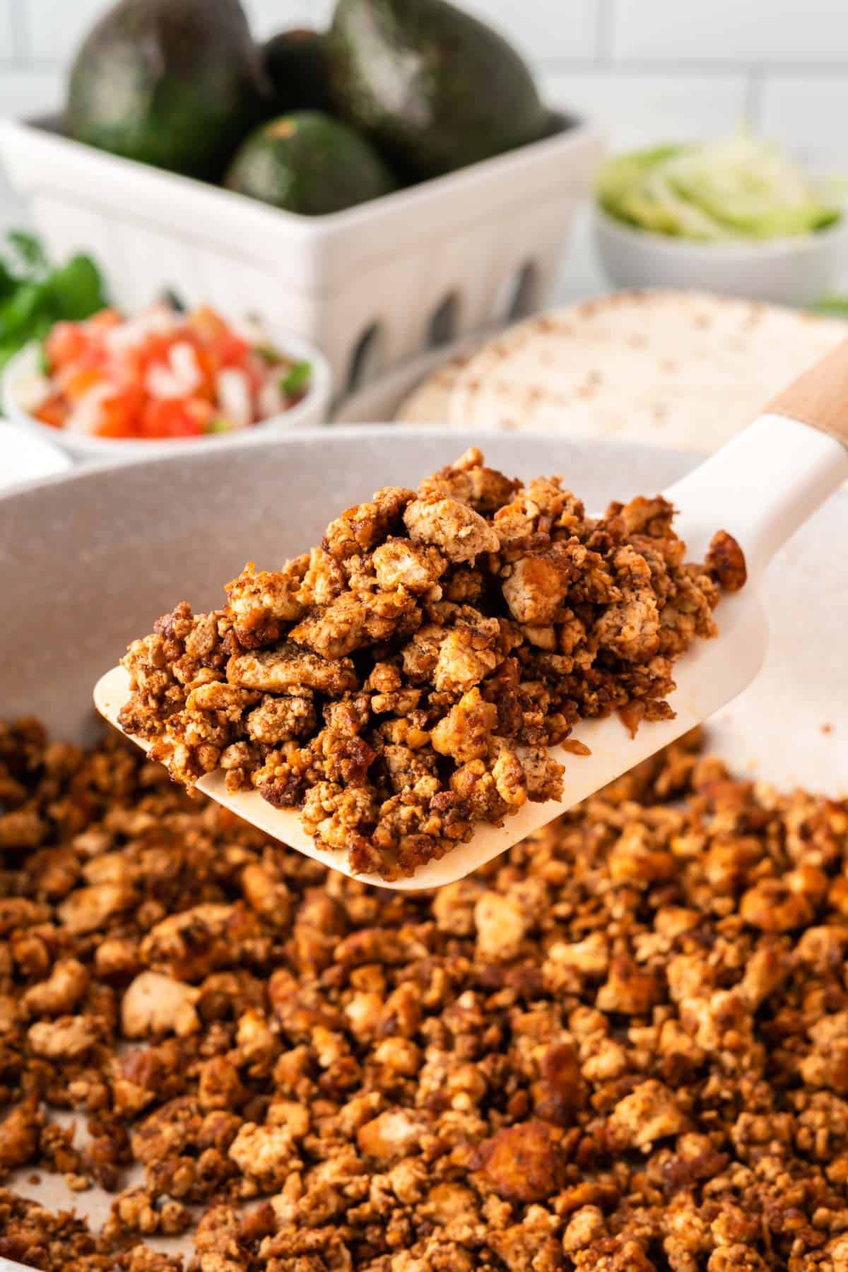 spatula taking tofu taco crumbles from the pan