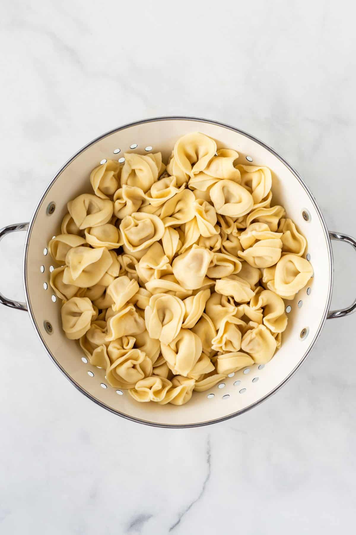 cooked tortellini in a collander