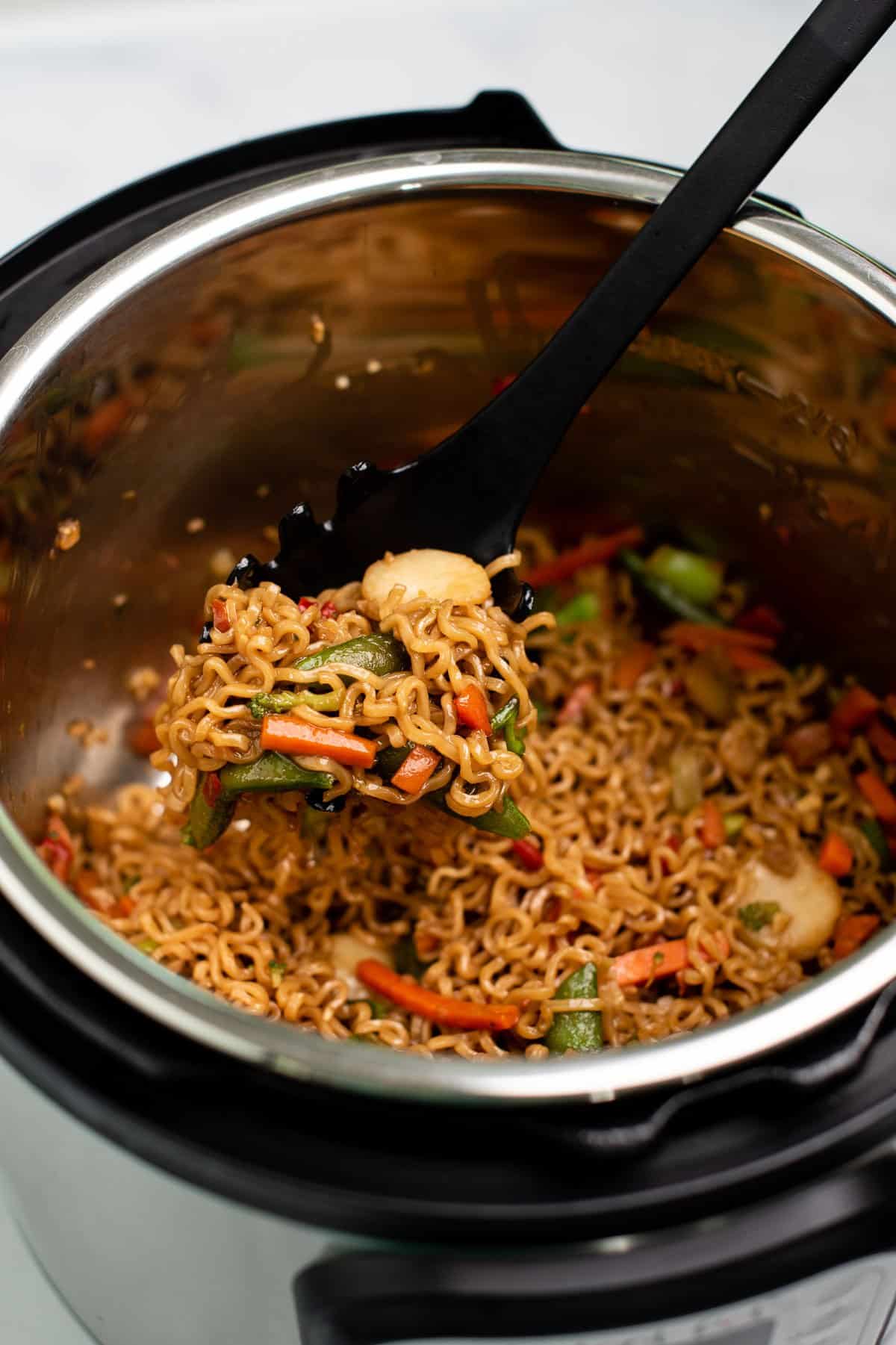 taking a scoop of stir fry noodles from the instant pot