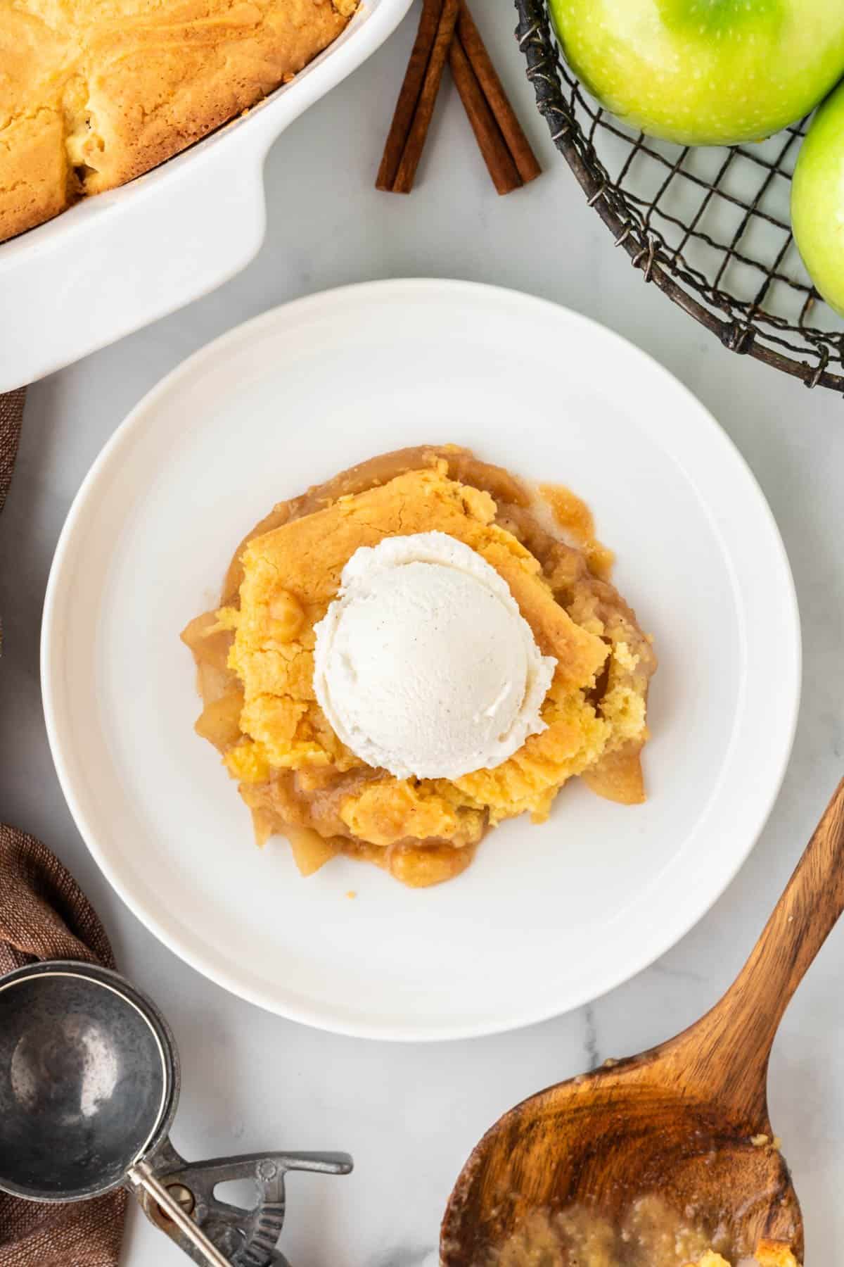 apple cobbler on a plate topped with vanilla ice cream