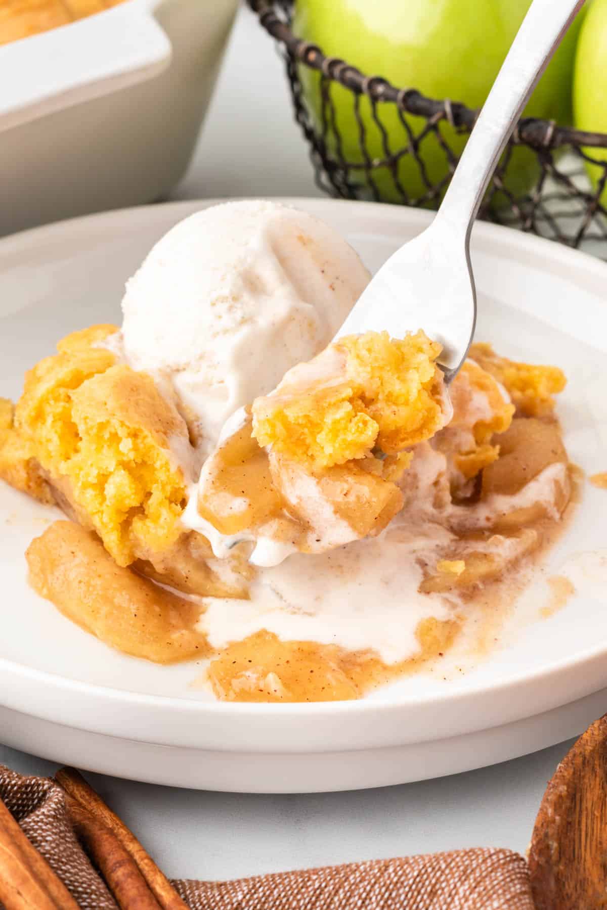 a fork taking a bite of cake mix apple cobbler