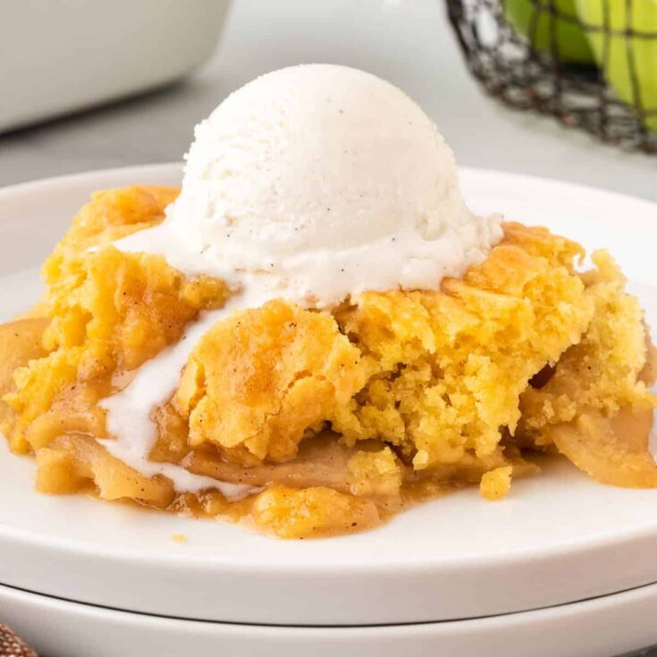 apple cobbler on a plate with a scoop of ice cream on top