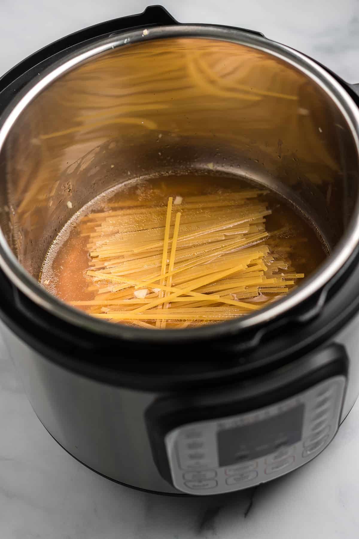 linguini noodles and vegetable broth in the instant pot