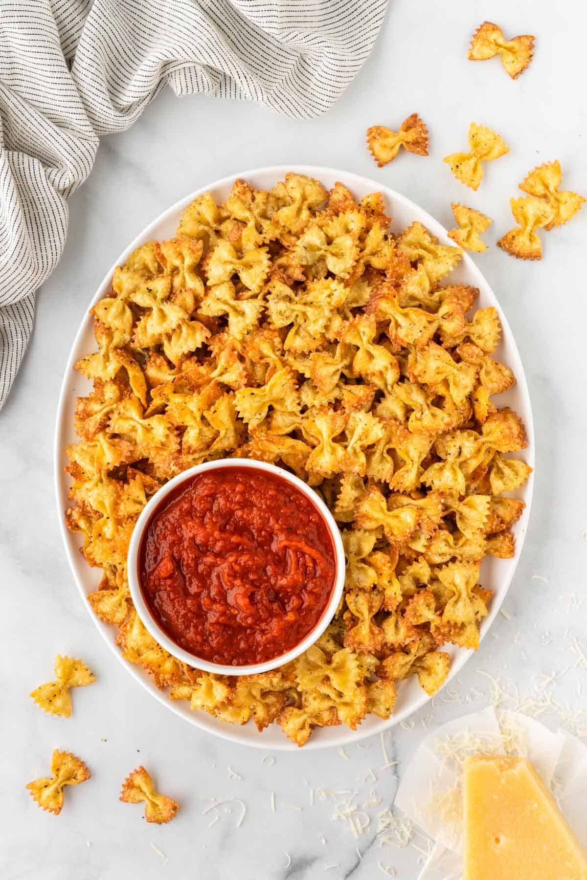 pasta chips next to a bowl of marinara for dipping