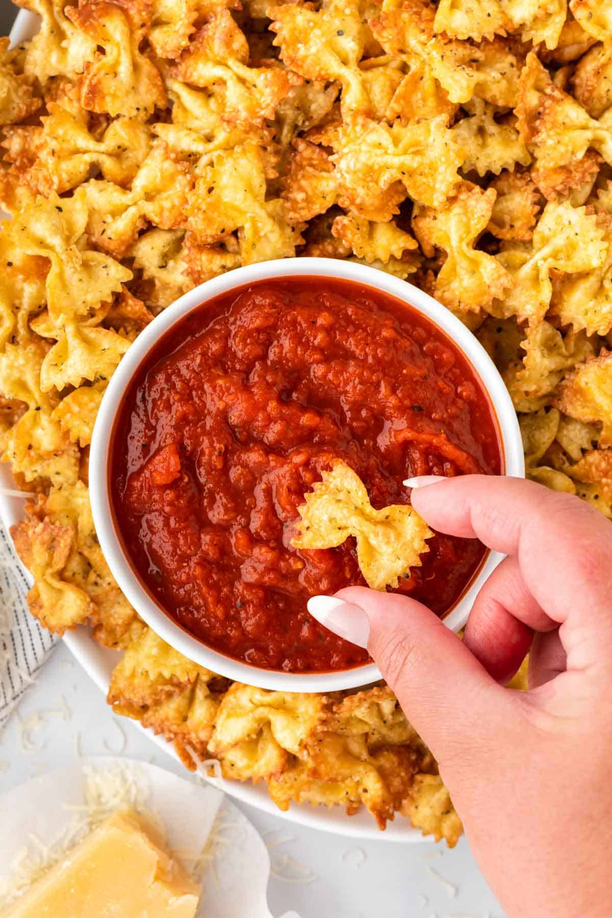 pasta chips next to a bowl of marinara for dipping