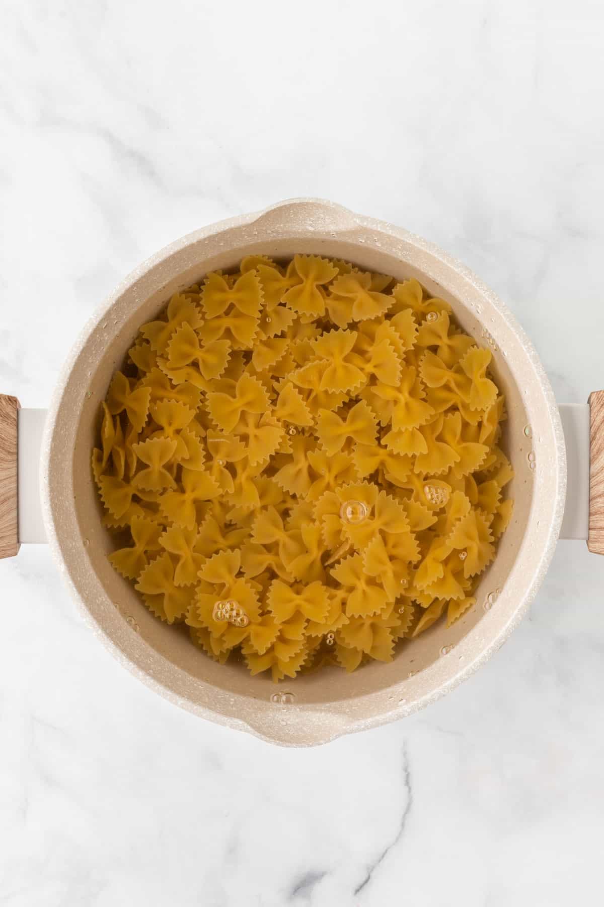 bowtie pasta being cooked in a sauce pan