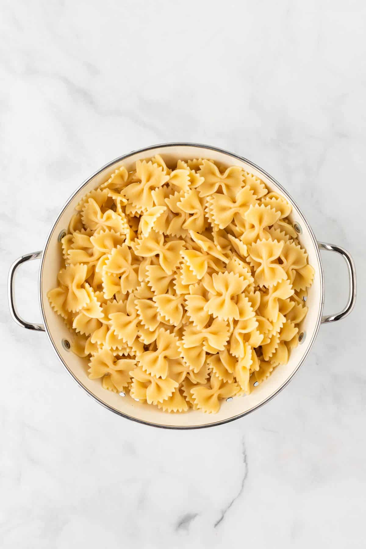 cooked bowtie pasta in a strainer