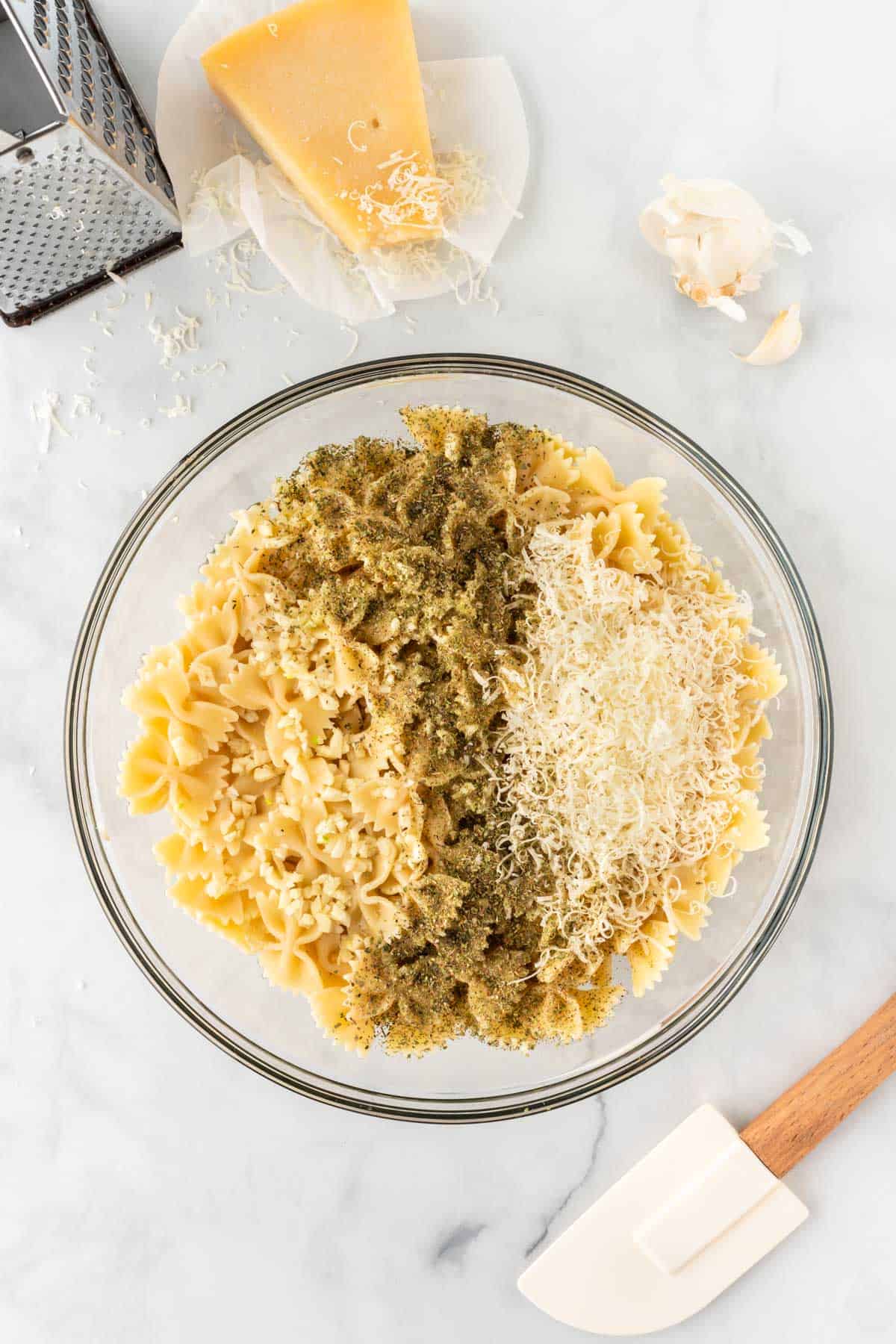 adding the spices and parmesan cheese to the pasta