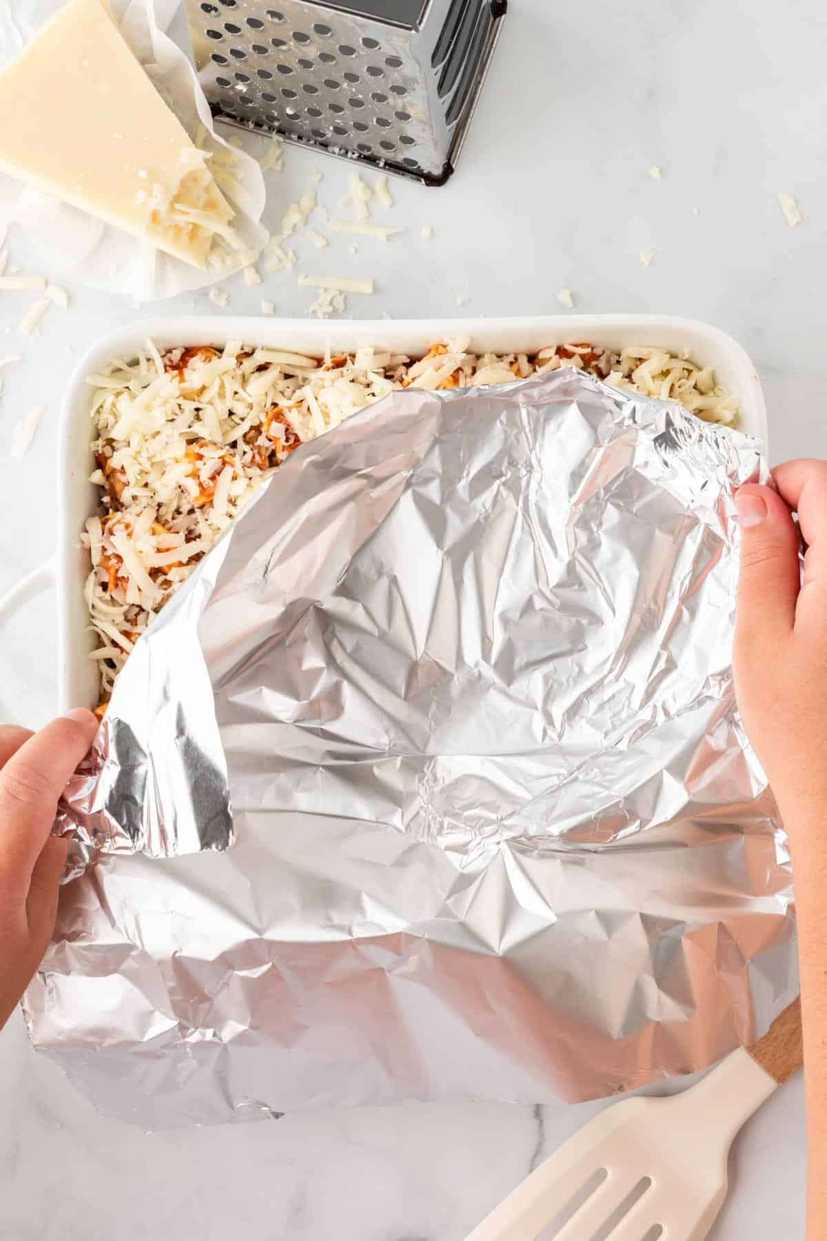 covering the baking dish with aluminum foil