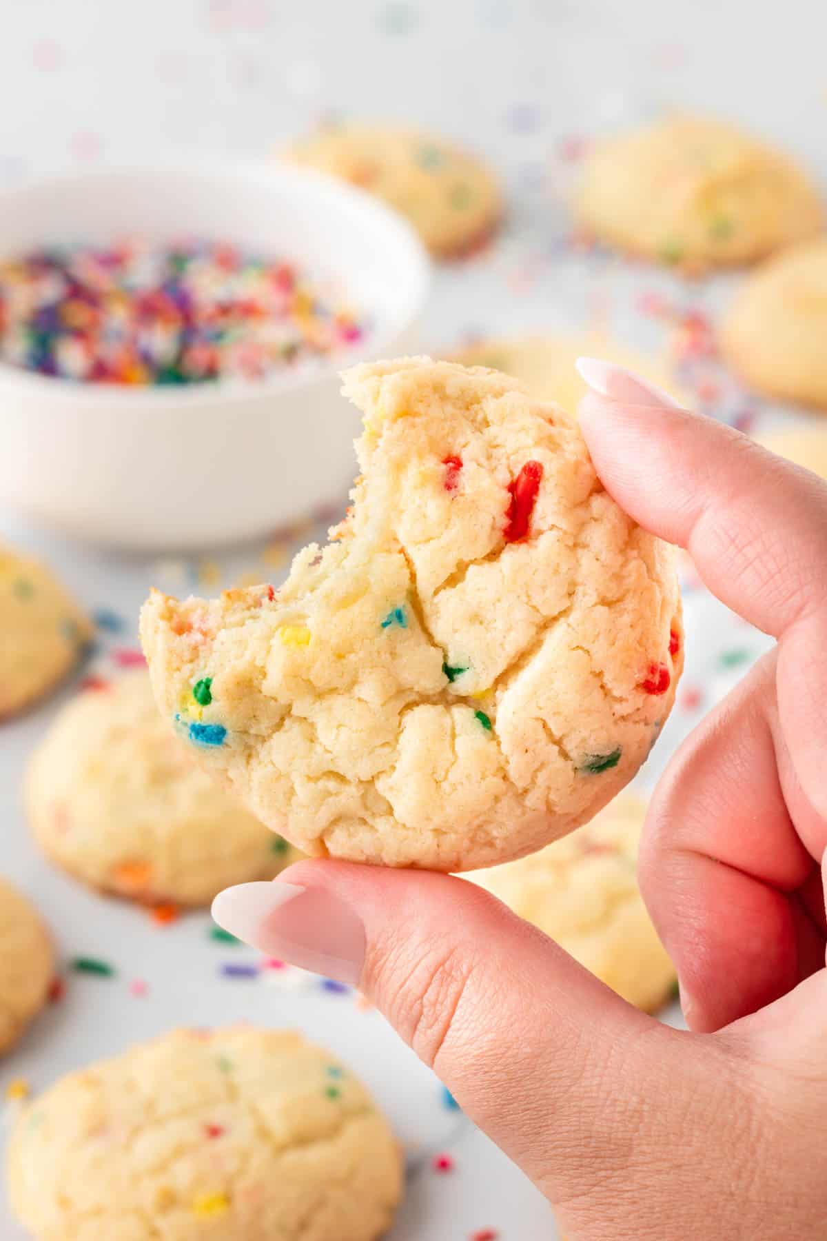 holding a funfetti cookie with a bite taken out