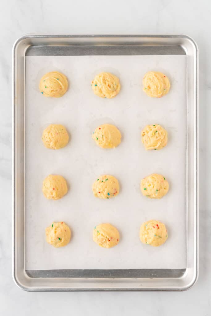 cookie dough in balls on a baking sheet