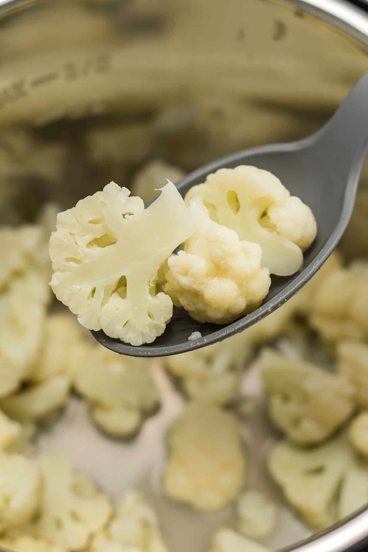 spoon taking cauliflower from the pot