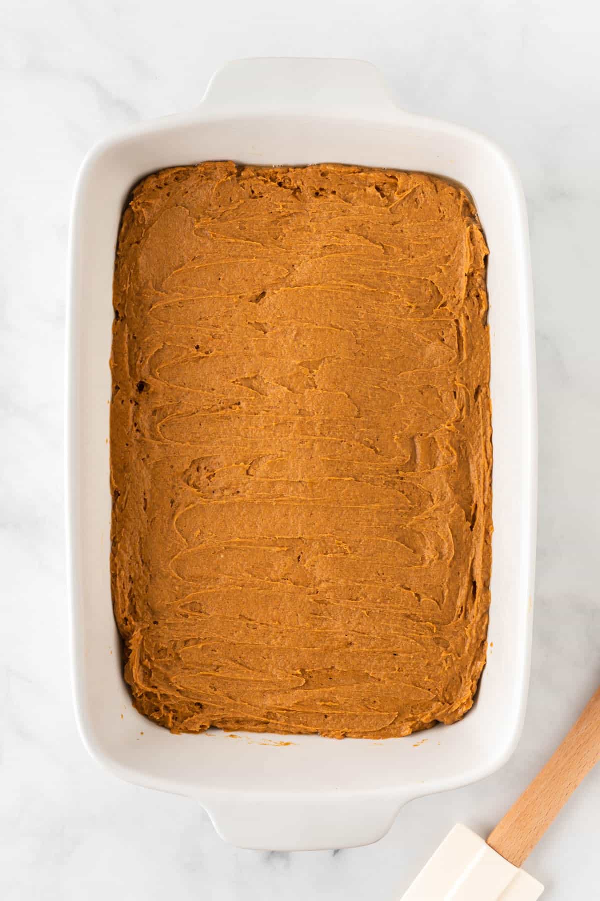 pumpkin batter spread out in a baking dish