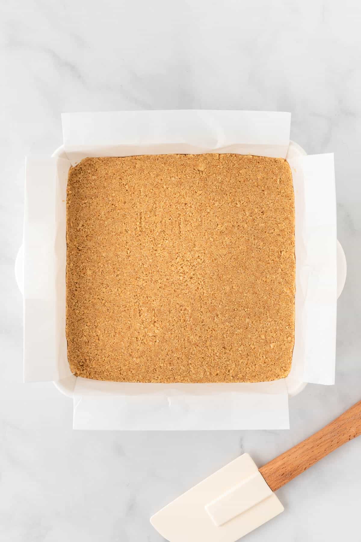 baking dish with graham cracker crust in it