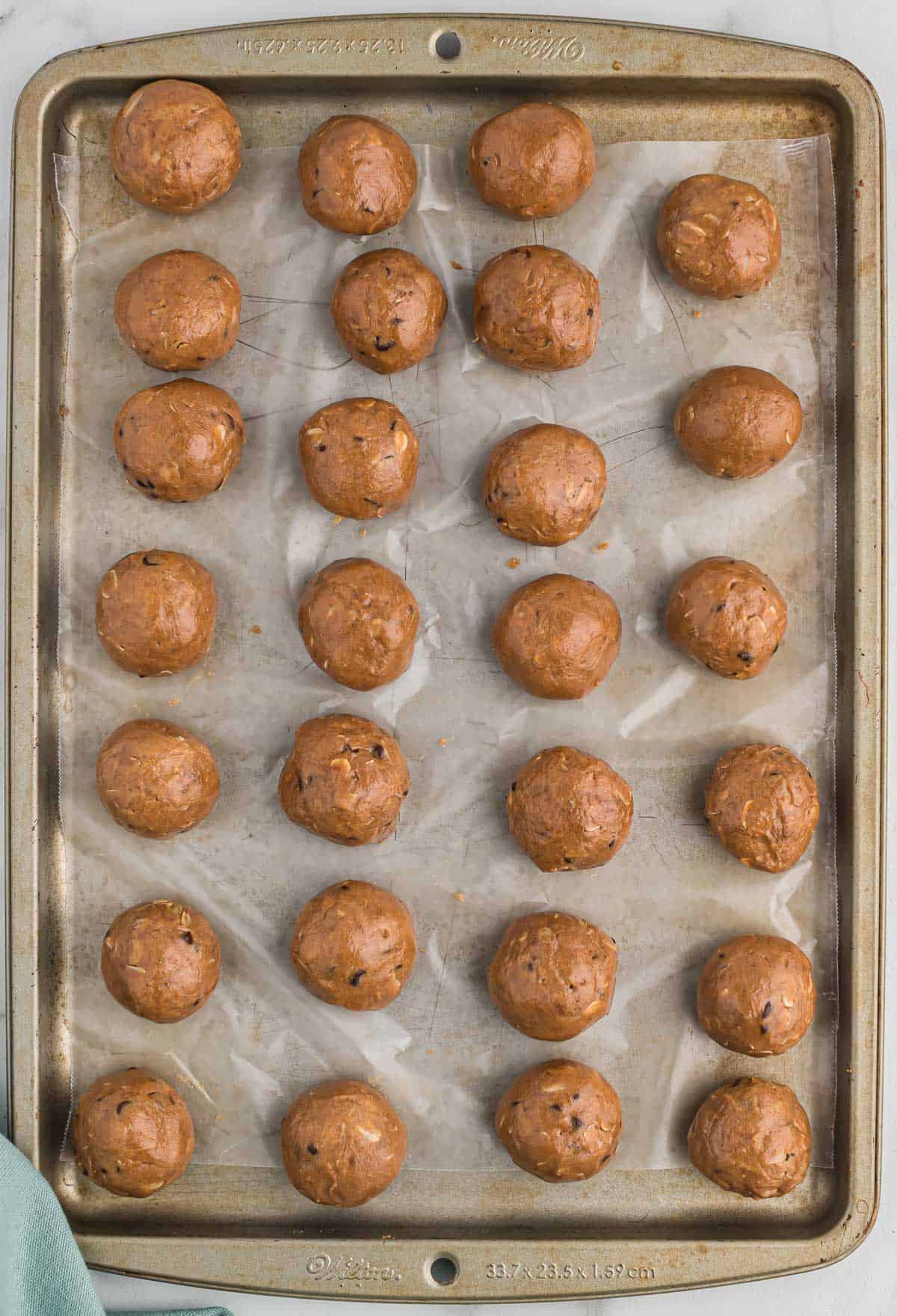 chocolate protein balls on a wax paper lined baking sheet