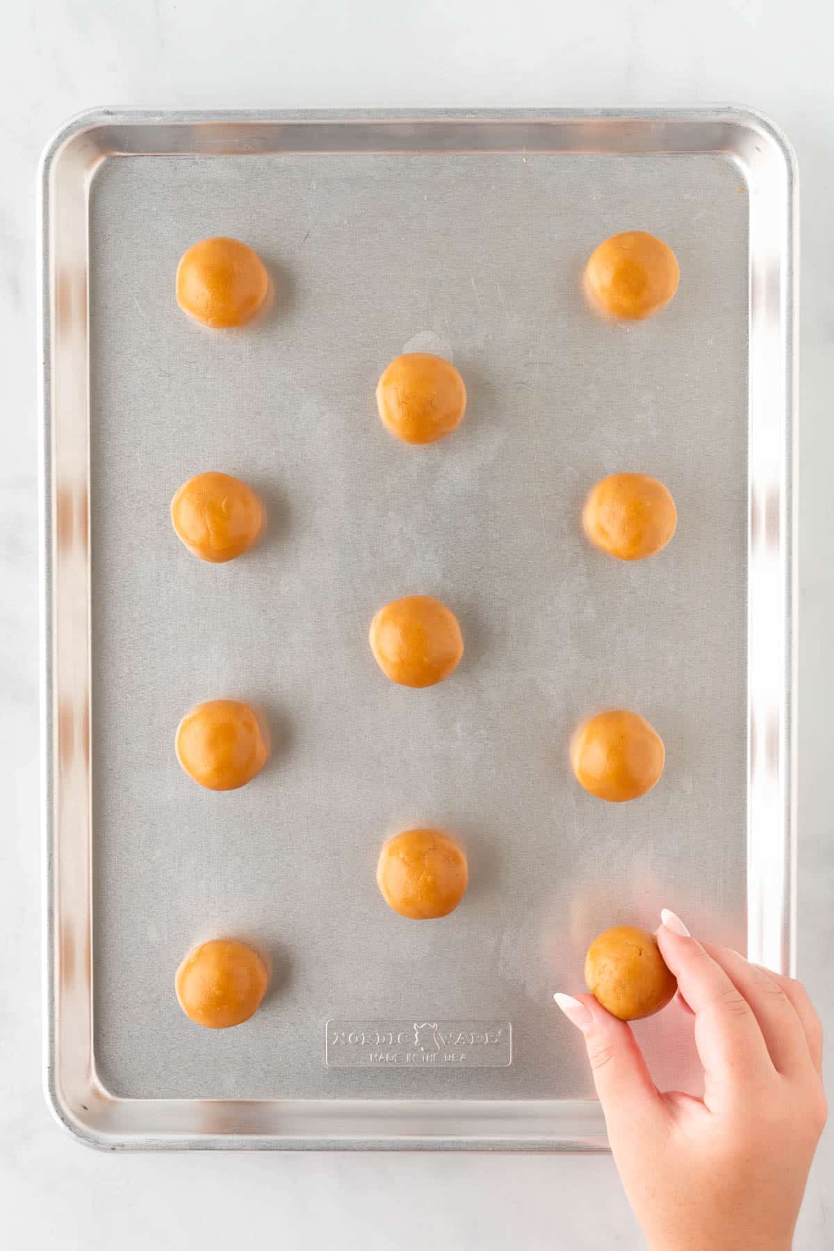 rolled balls of dough on a baking sheet