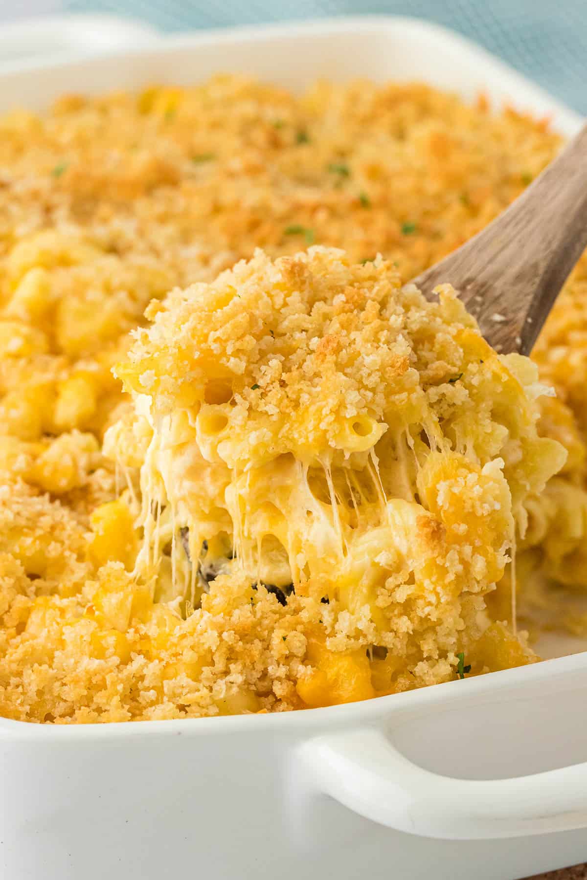 scooping mac and cheese from the baking dish