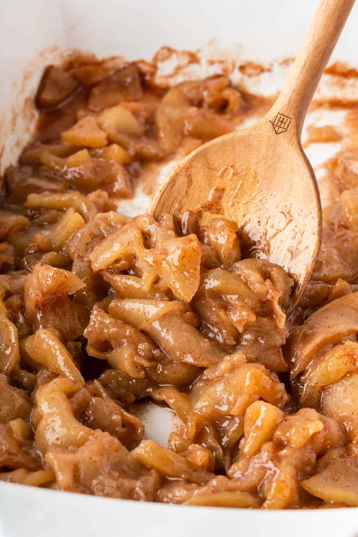 wooden spoon scooping baked cinnamon apples