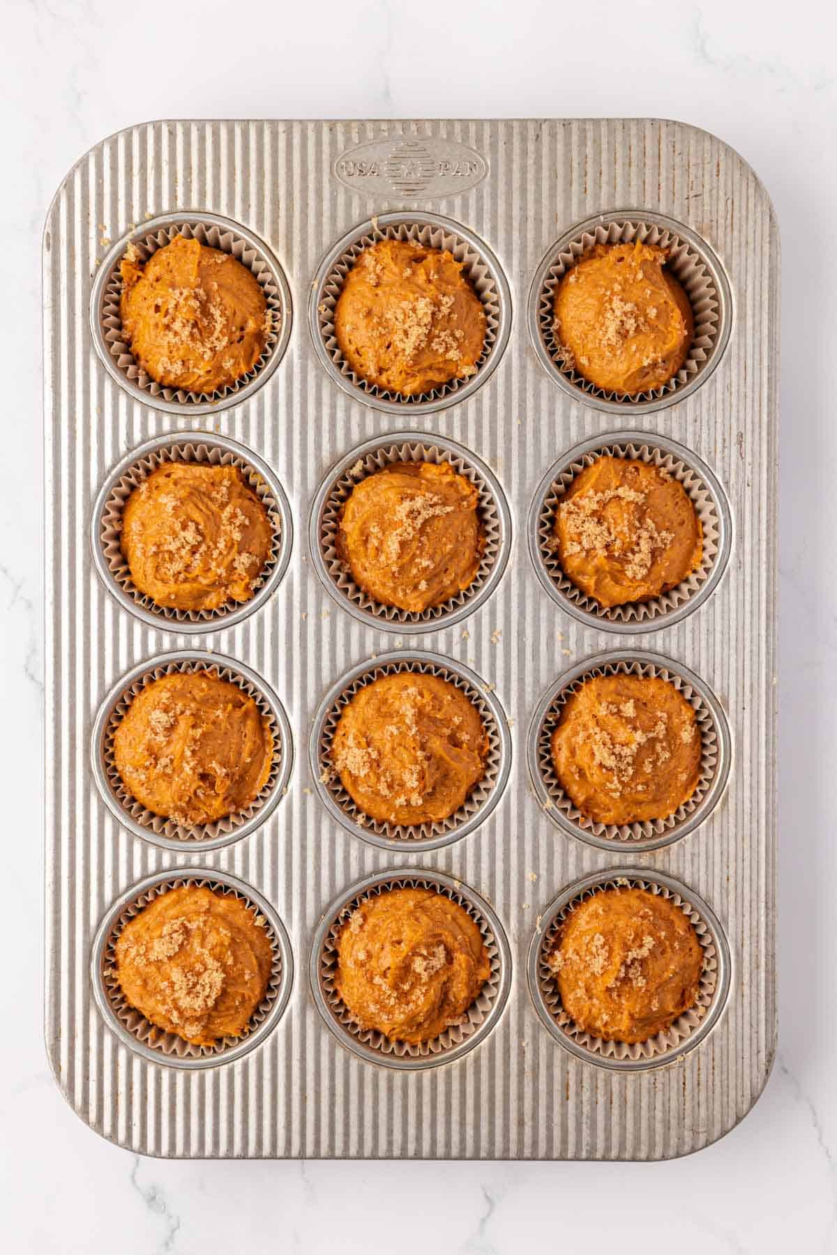 cake mix pumpkin muffin batter in a muffin tin