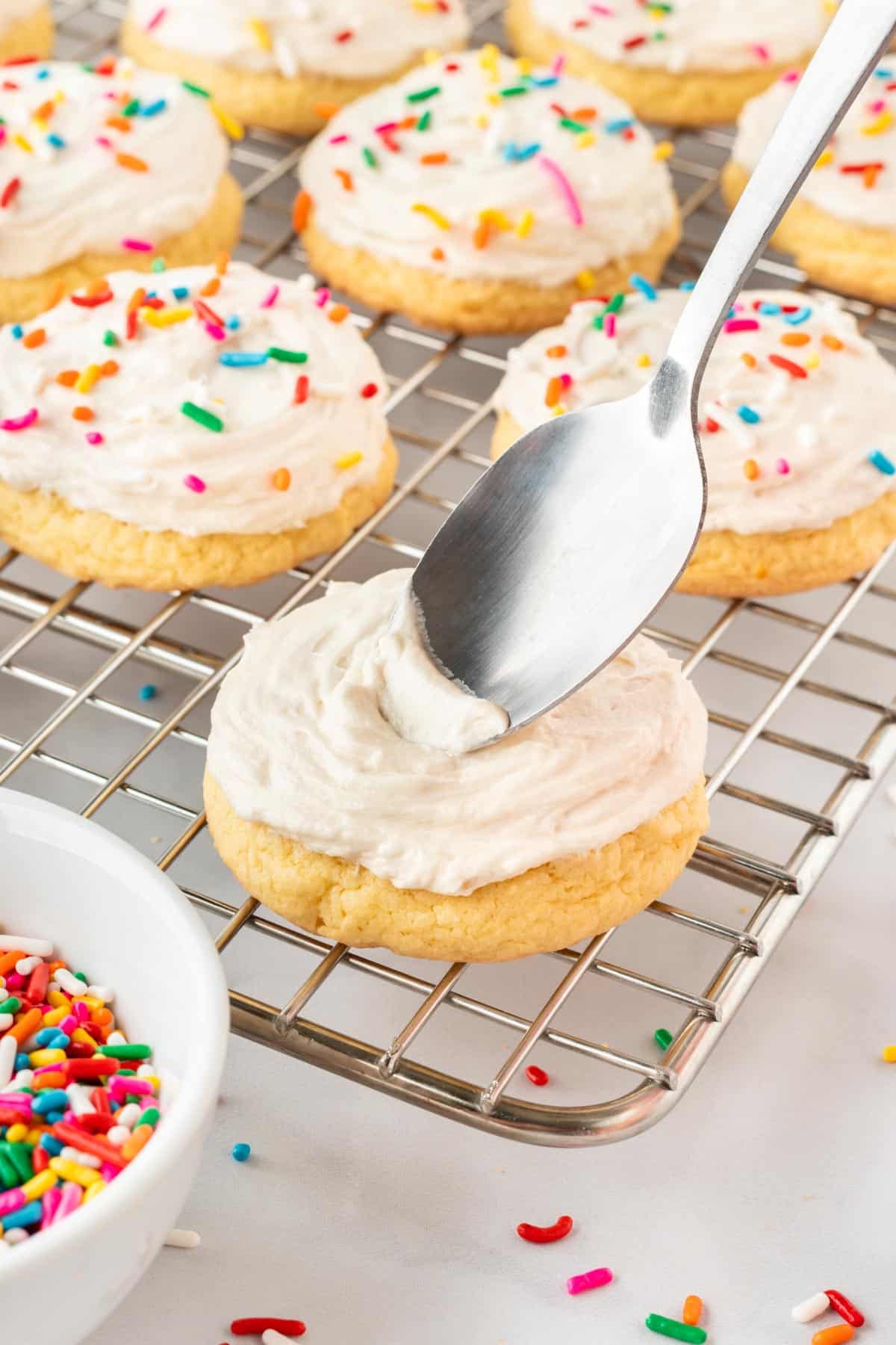 topping the sugar cookies with frosting