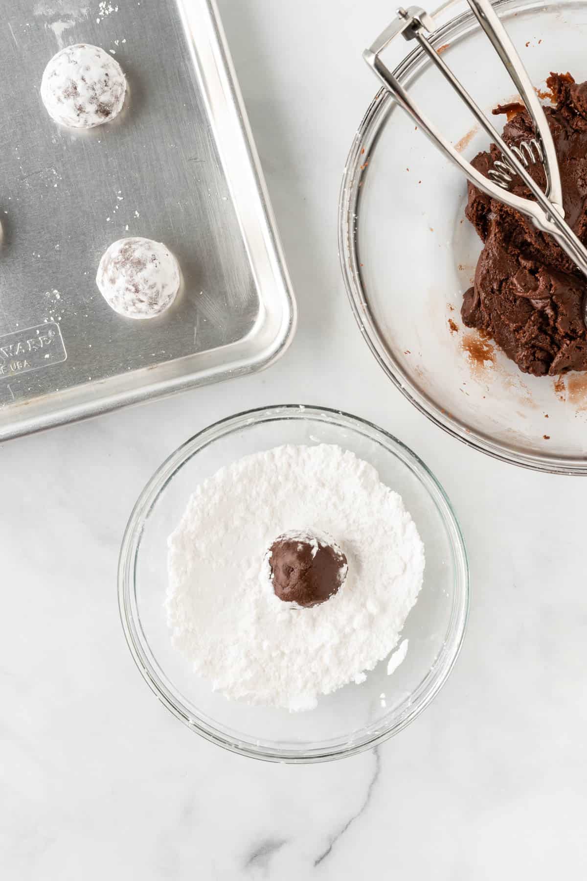 rolling a ball of dough in powdered sugar