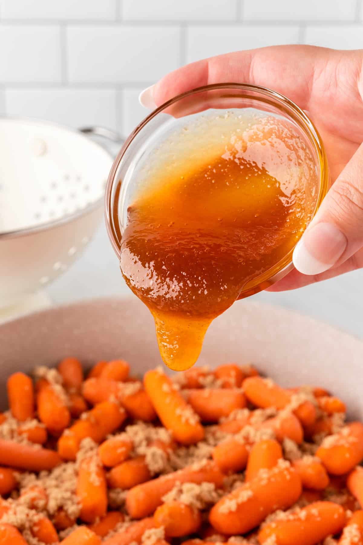 pouring honey onto the brown sugar carrots