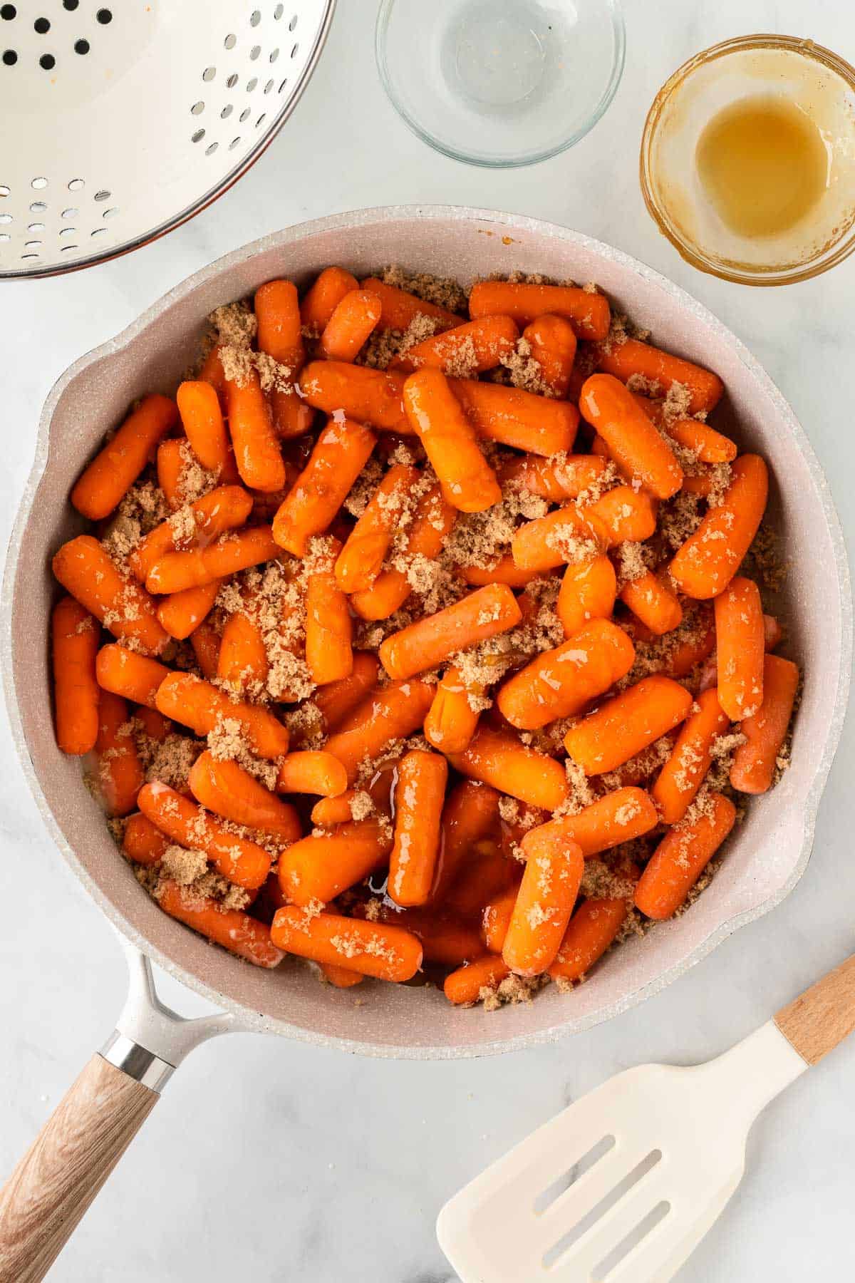 adding brown sugar to the carrots