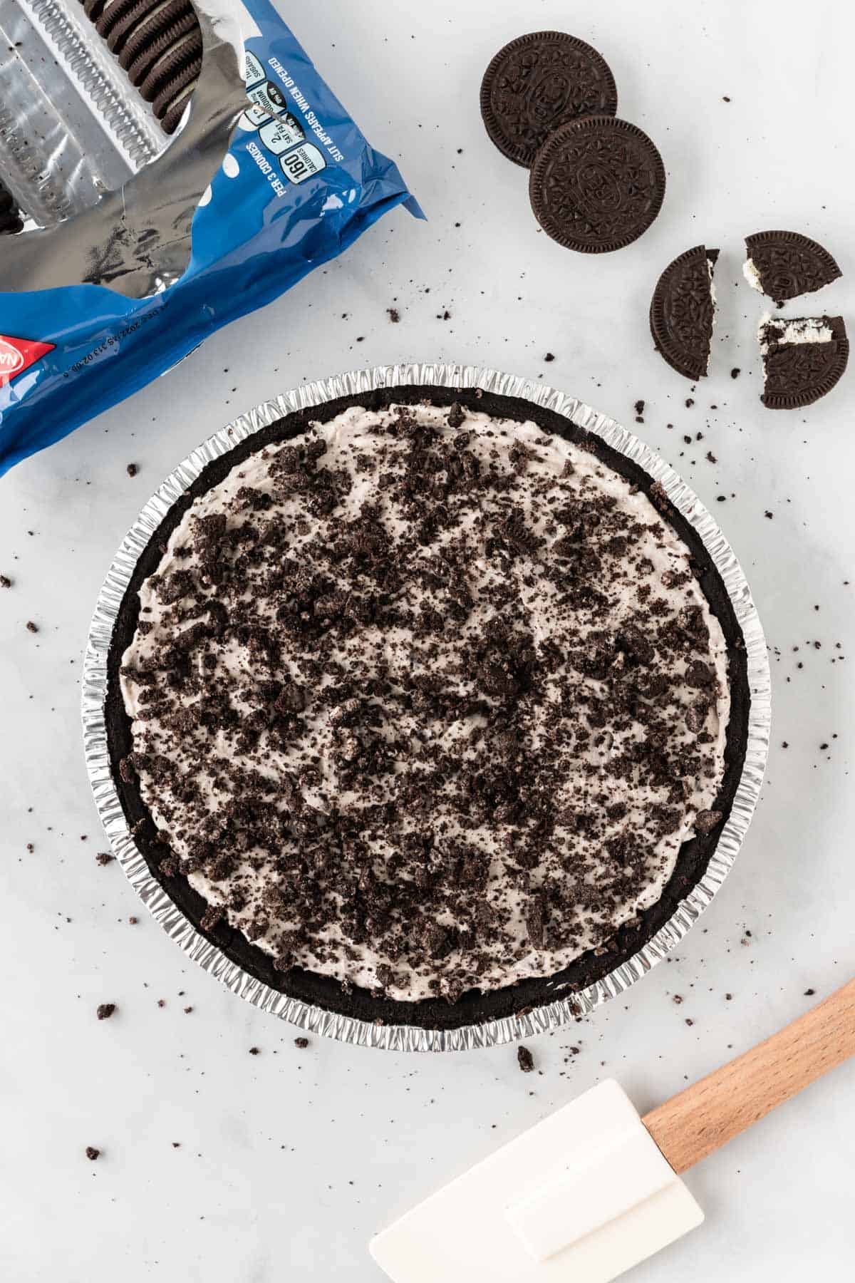 topping the pie with crushed oreos