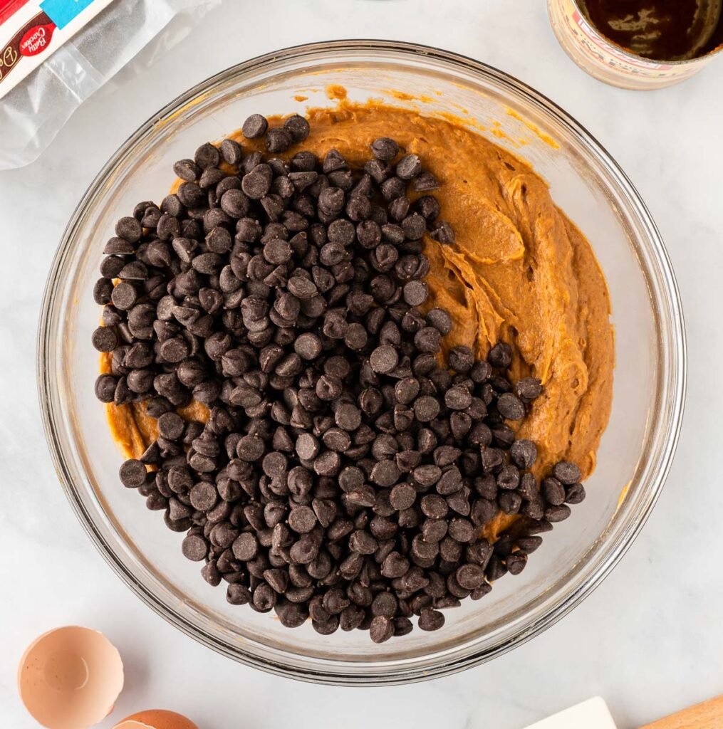 adding chocolate chips to the cookie batter