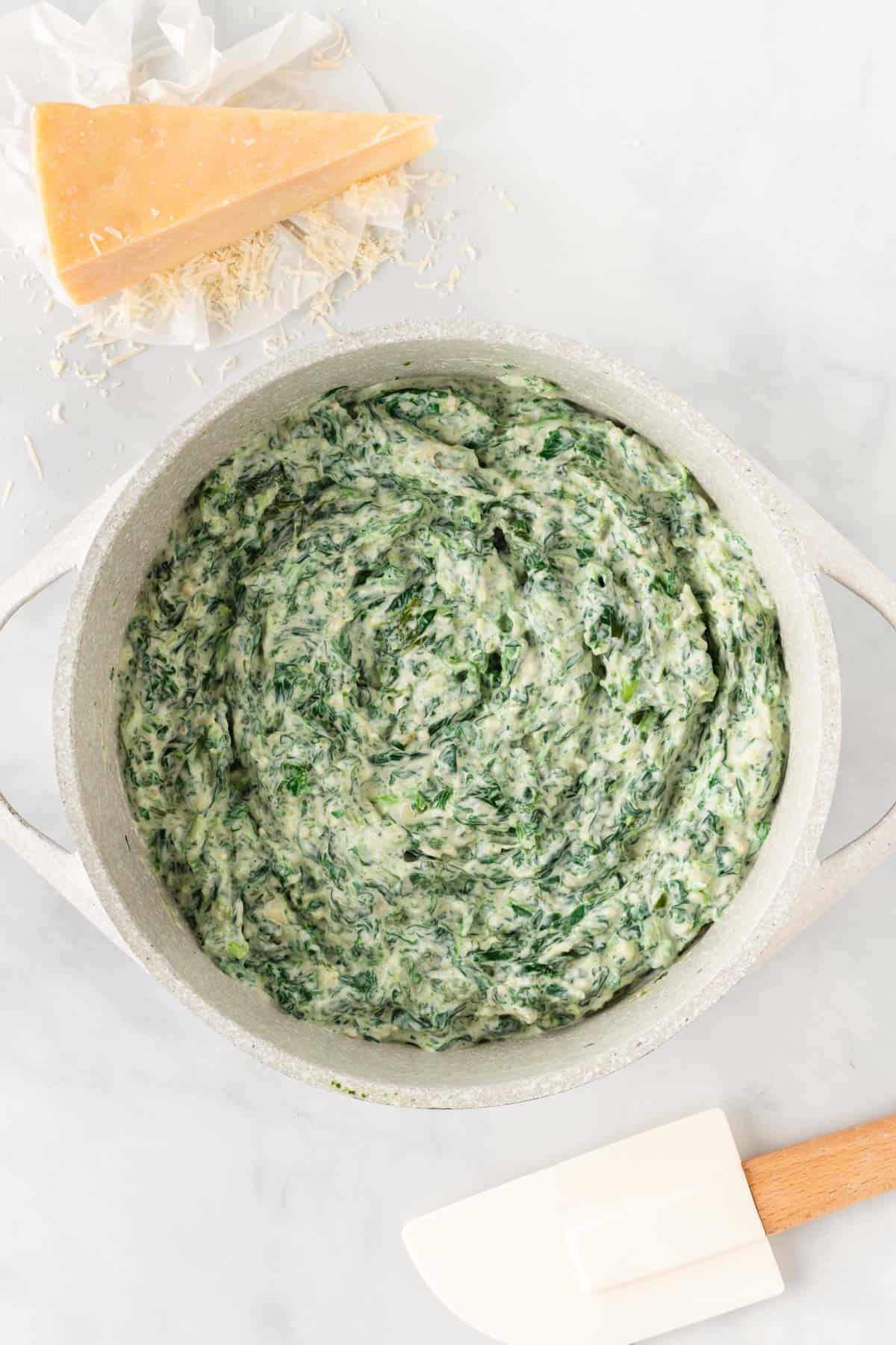 melted creamy spinach dip in a sauce pan