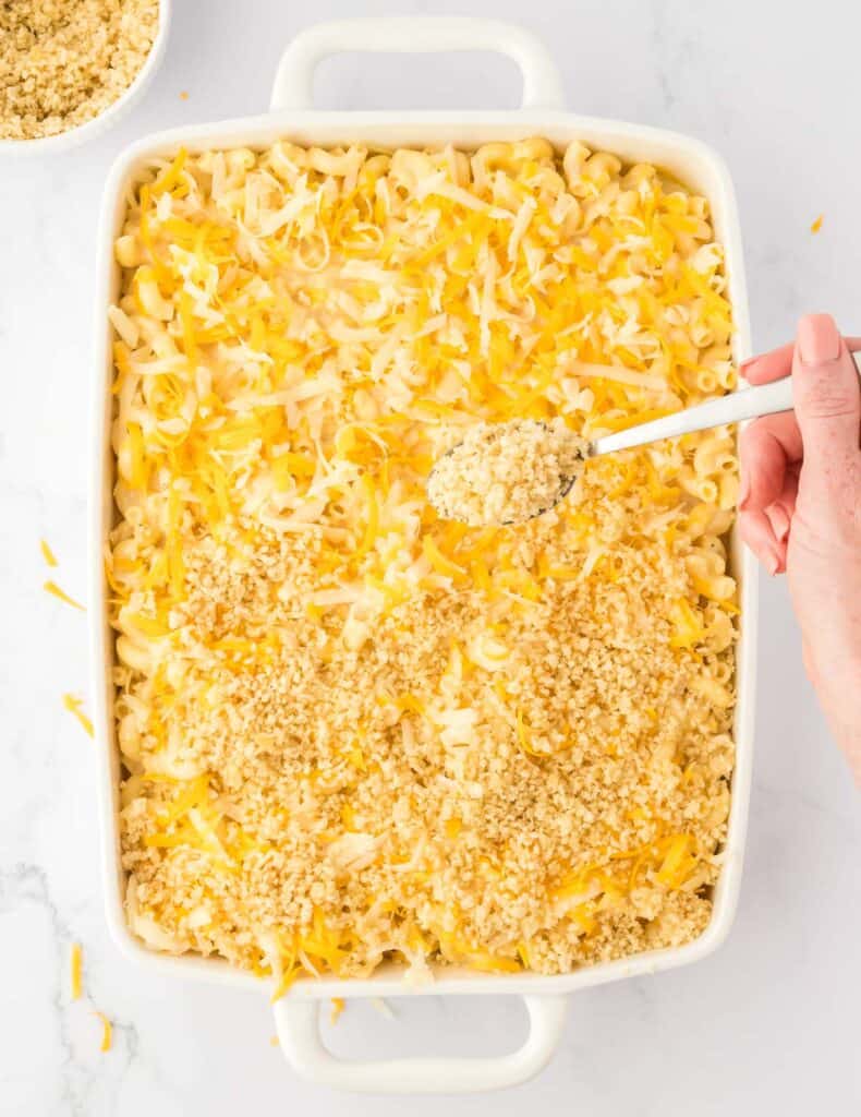 adding the bread crumb topping to the mac and cheese