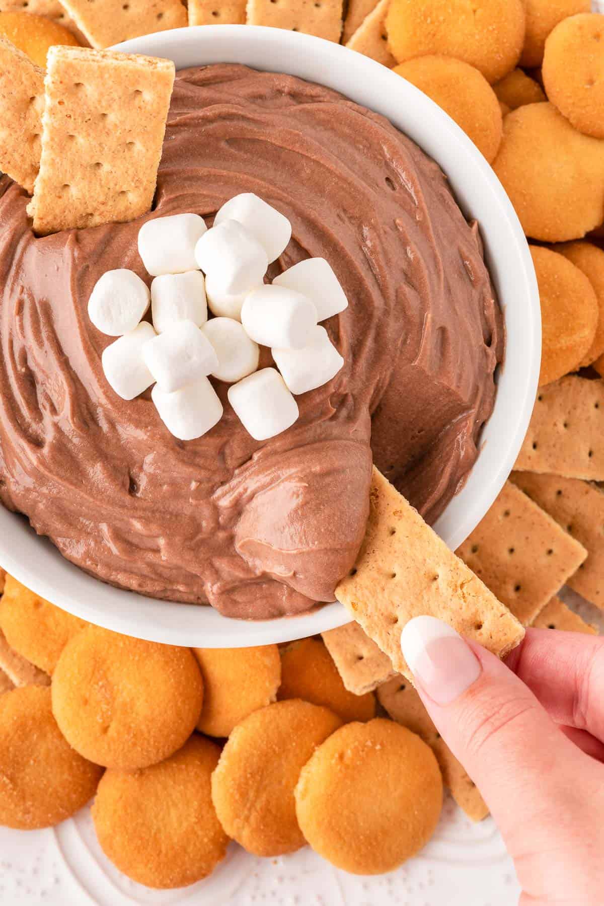 dipping a graham cracker into hot chocolate dip